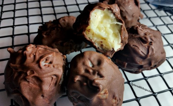 Mounds Coconut Copycat Chocolate Balls on a wire cooling rack with a bite missing from the front one