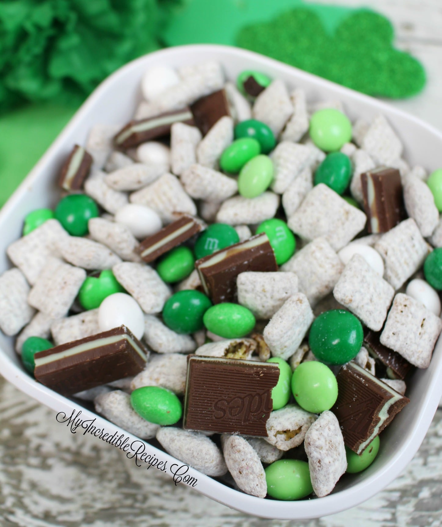 overhead shot of Andes Mint Muddy Buddies in a pretty white bowl on a whitewashed wood table