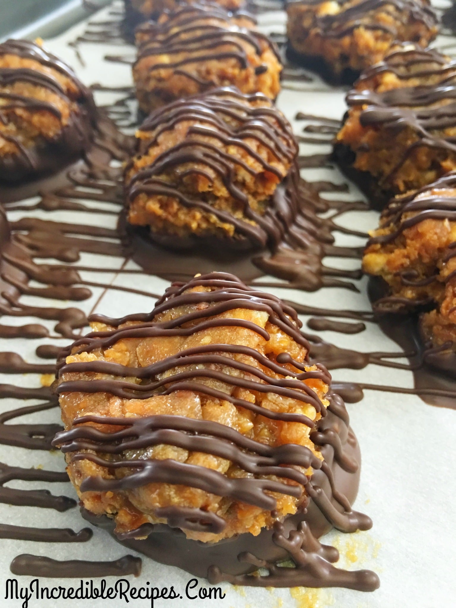 Samoa Bites on a parchment paper lined baking sheet drizzled with chocolate