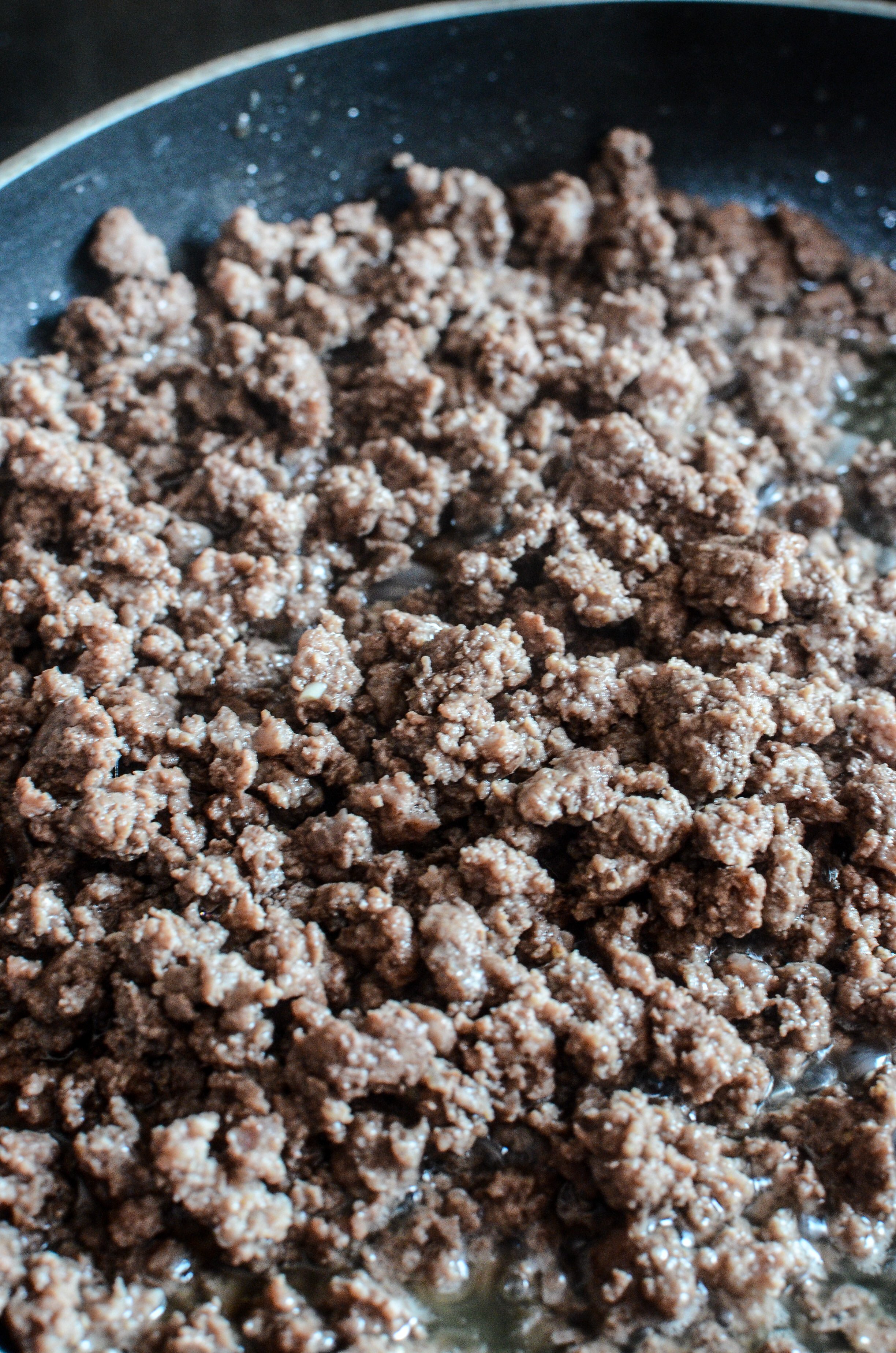 Ground beef in a frying pan cooking