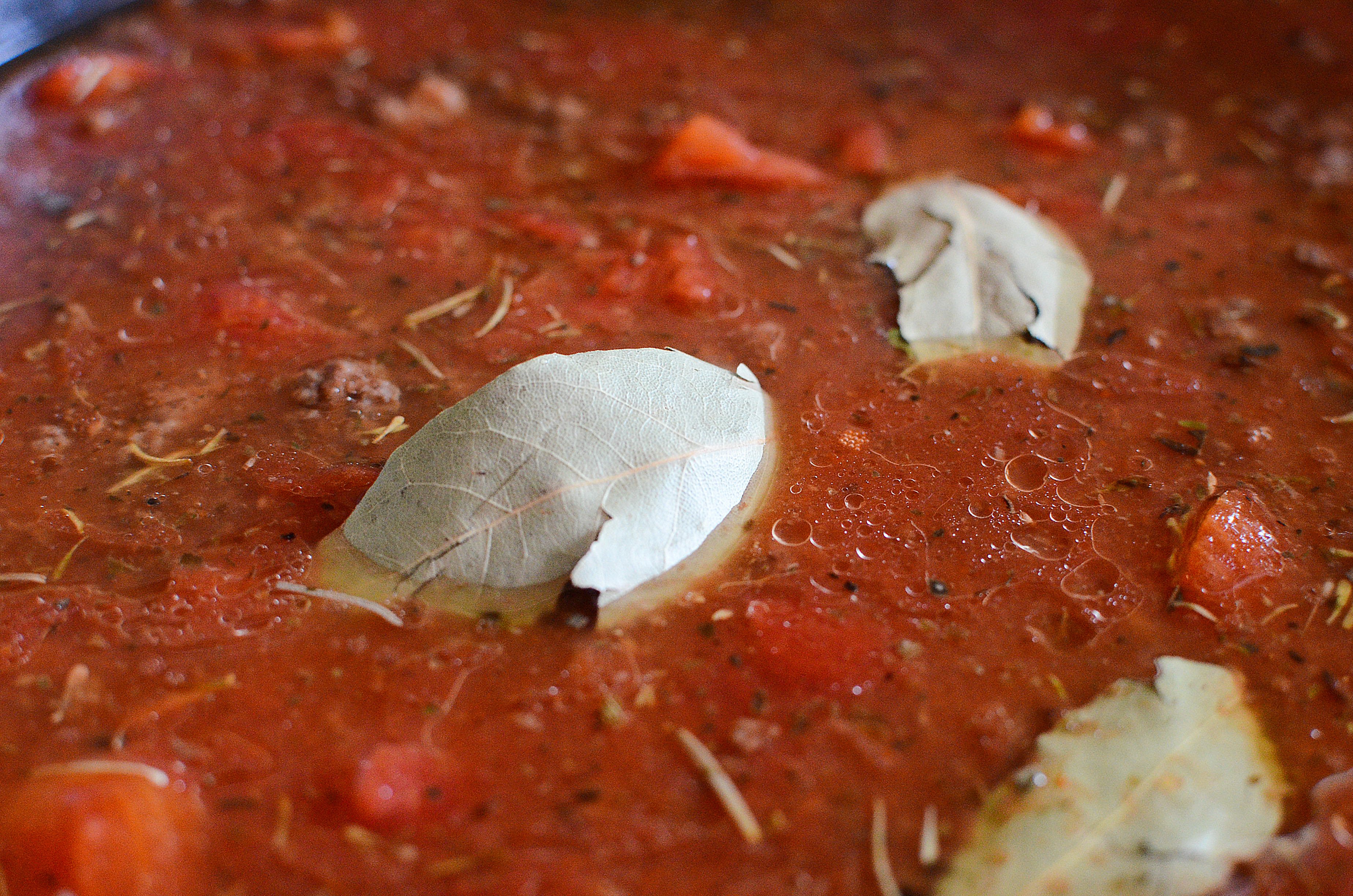 Old Fashioned Goulash simmering in a pot topped with bay leaves