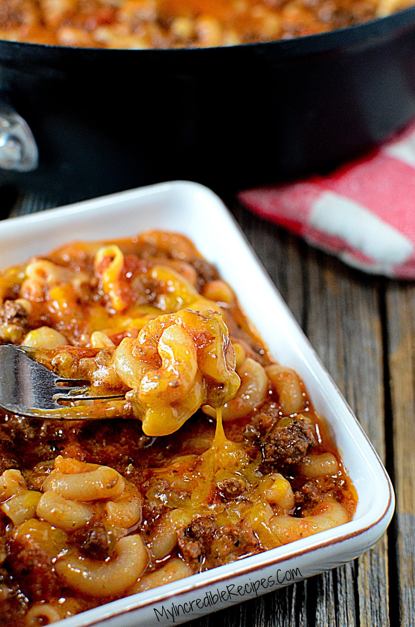 Old Fashioned Goulash in a white bowl with a fork grabbing a bite