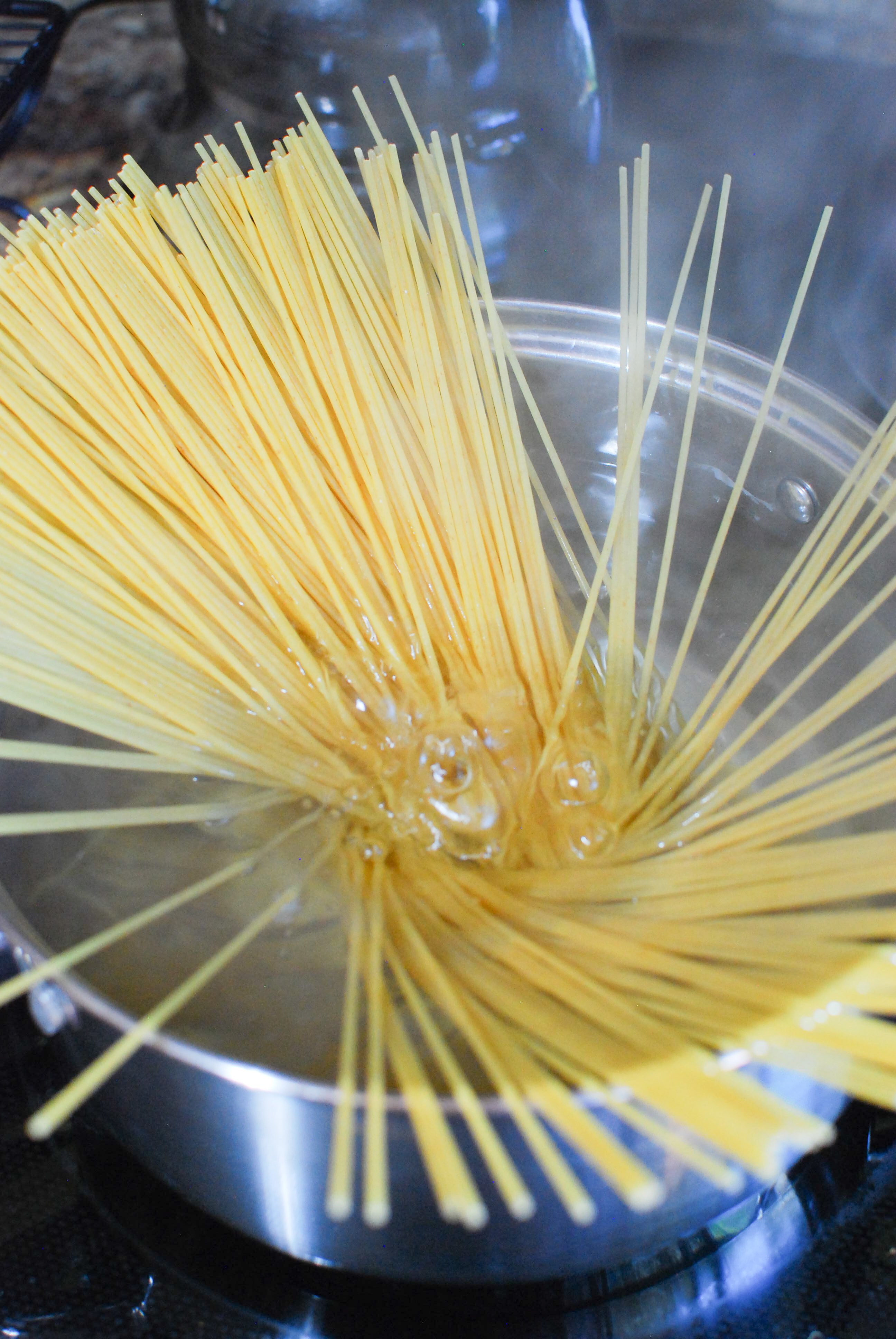 Spaghetti uncooked going into boiling water