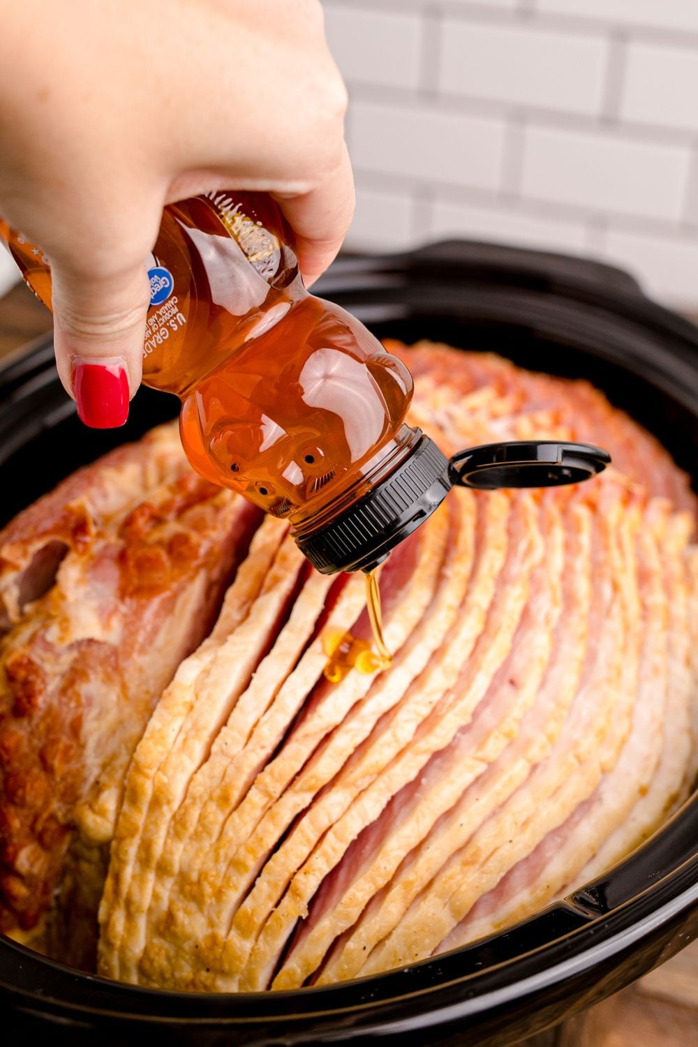 honey drizzling over a ham in slow cooker 