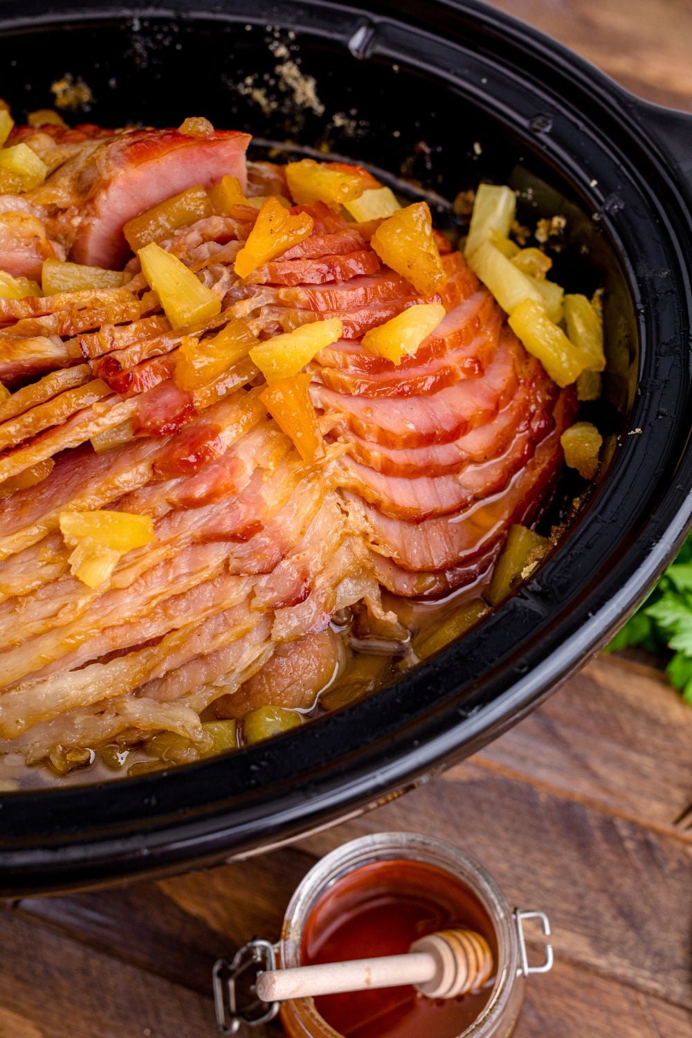 ham in crockpot with a honey jar on the side