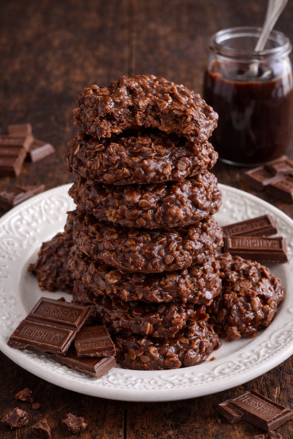 Chocolate Peanut Butter No Bake Cookies on a white plate stacked with a bite missing from the top one