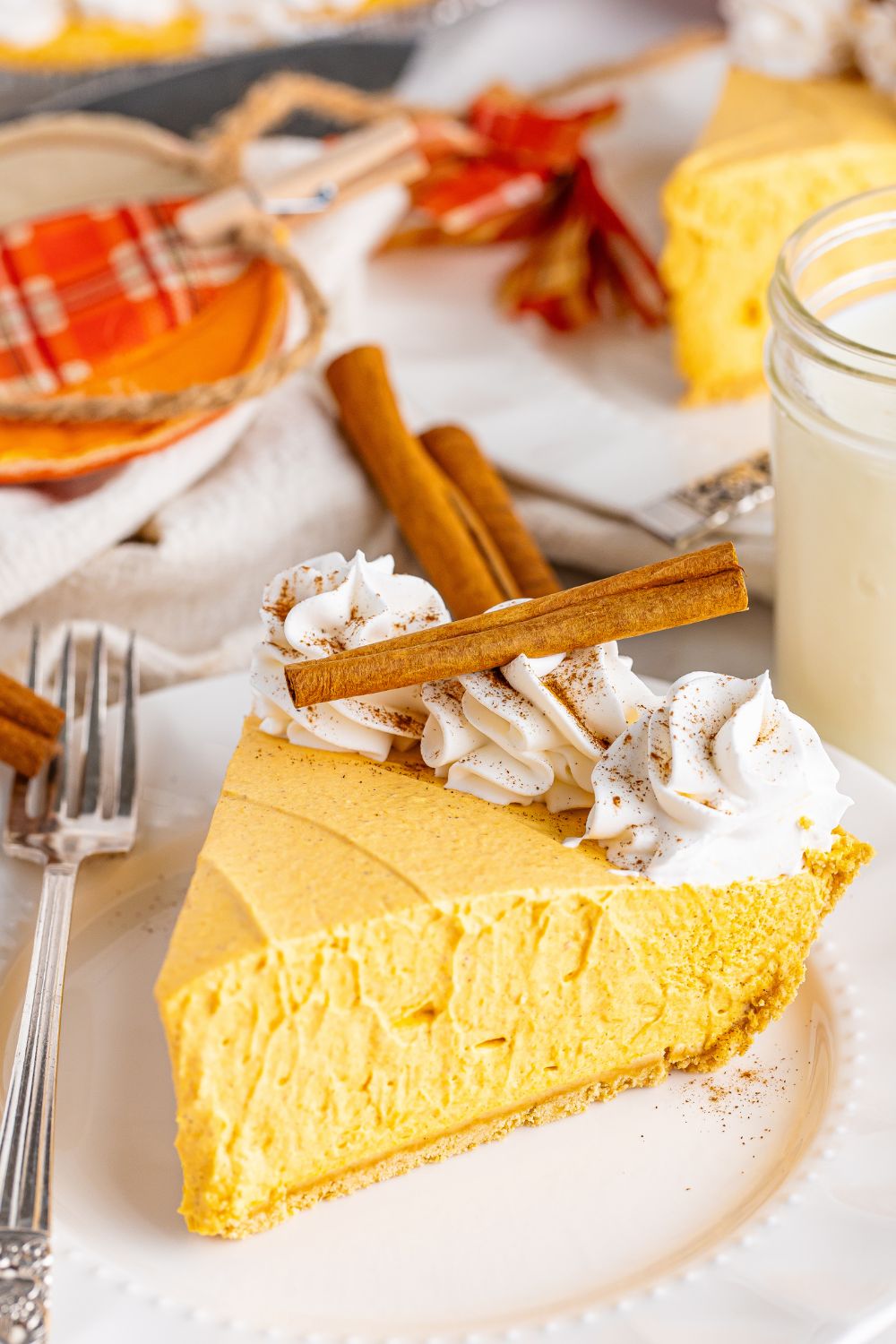 pumpkin cheesecake on plate with cinnamon stucks on top