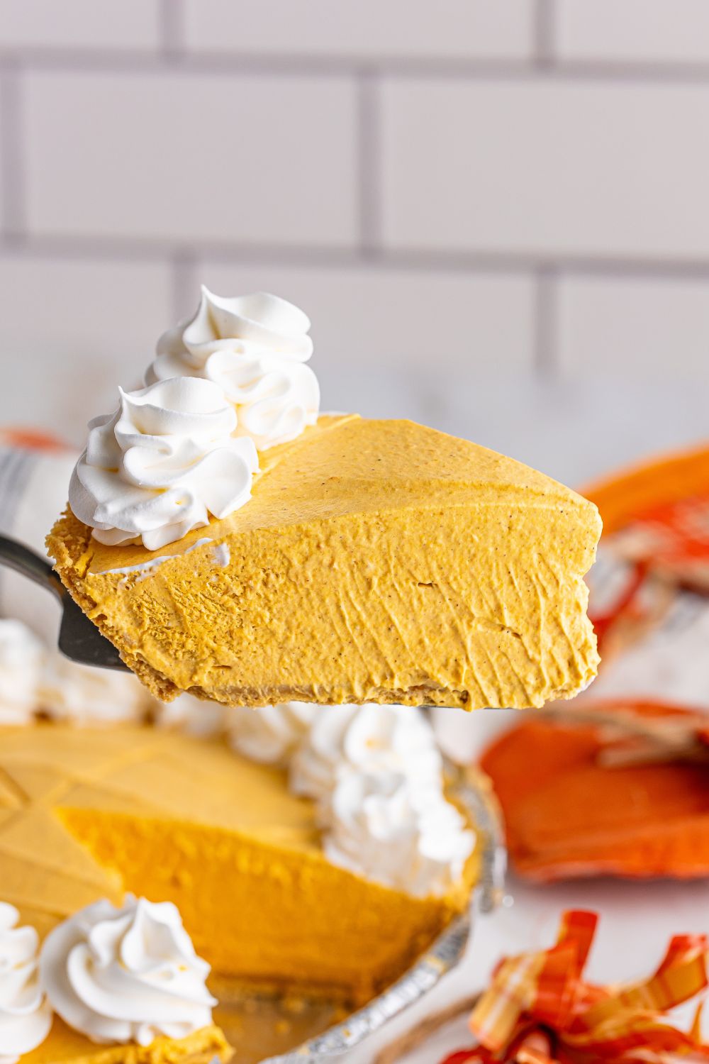 pumpkin pie cheesecake with slice on spatula