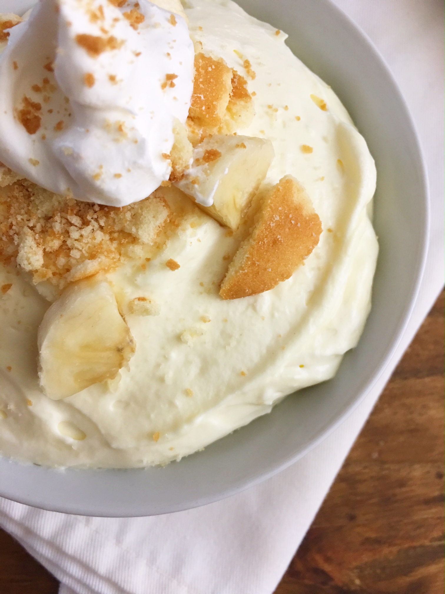 up close image of No Bake Banana Cream Pie Dip in a pretty white bowl on a wood table