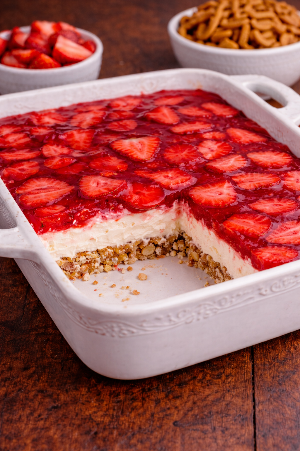Strawberry Pretzel Salad in a pretty white baking pan with a slice missing