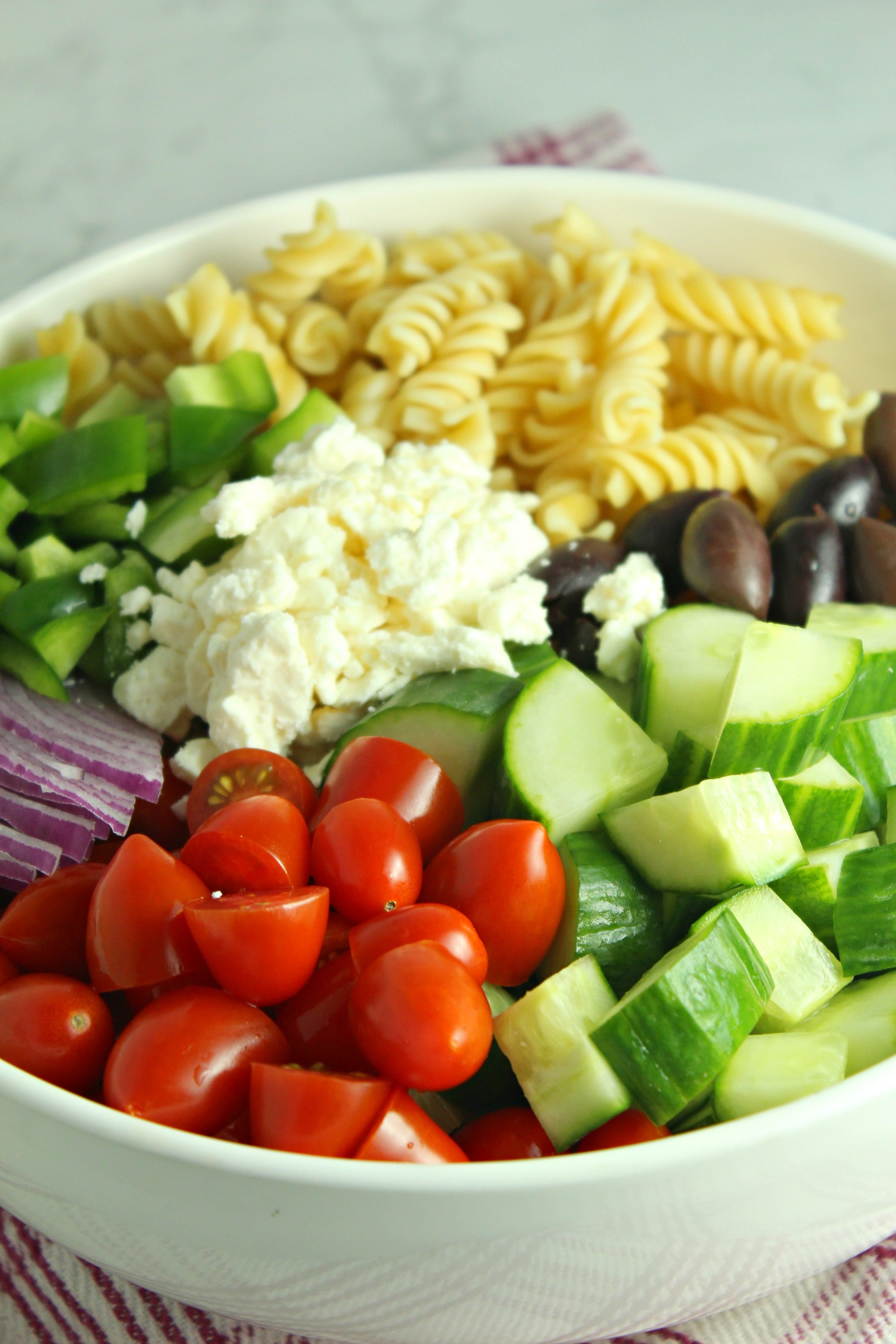 Greek Pasta Salad ingredients in a pretty white bowl