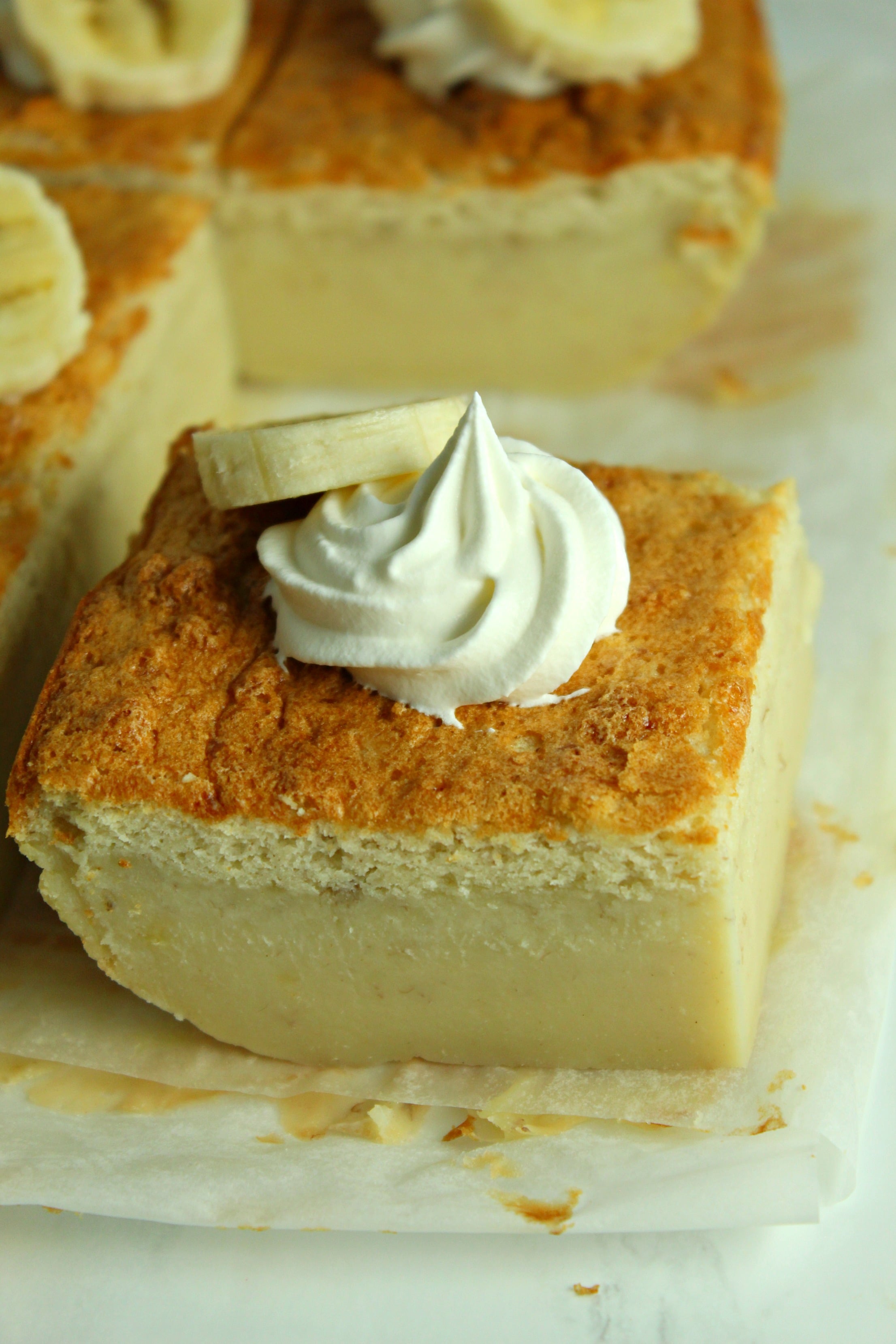 Banana Magic Cake slice on parchment paper