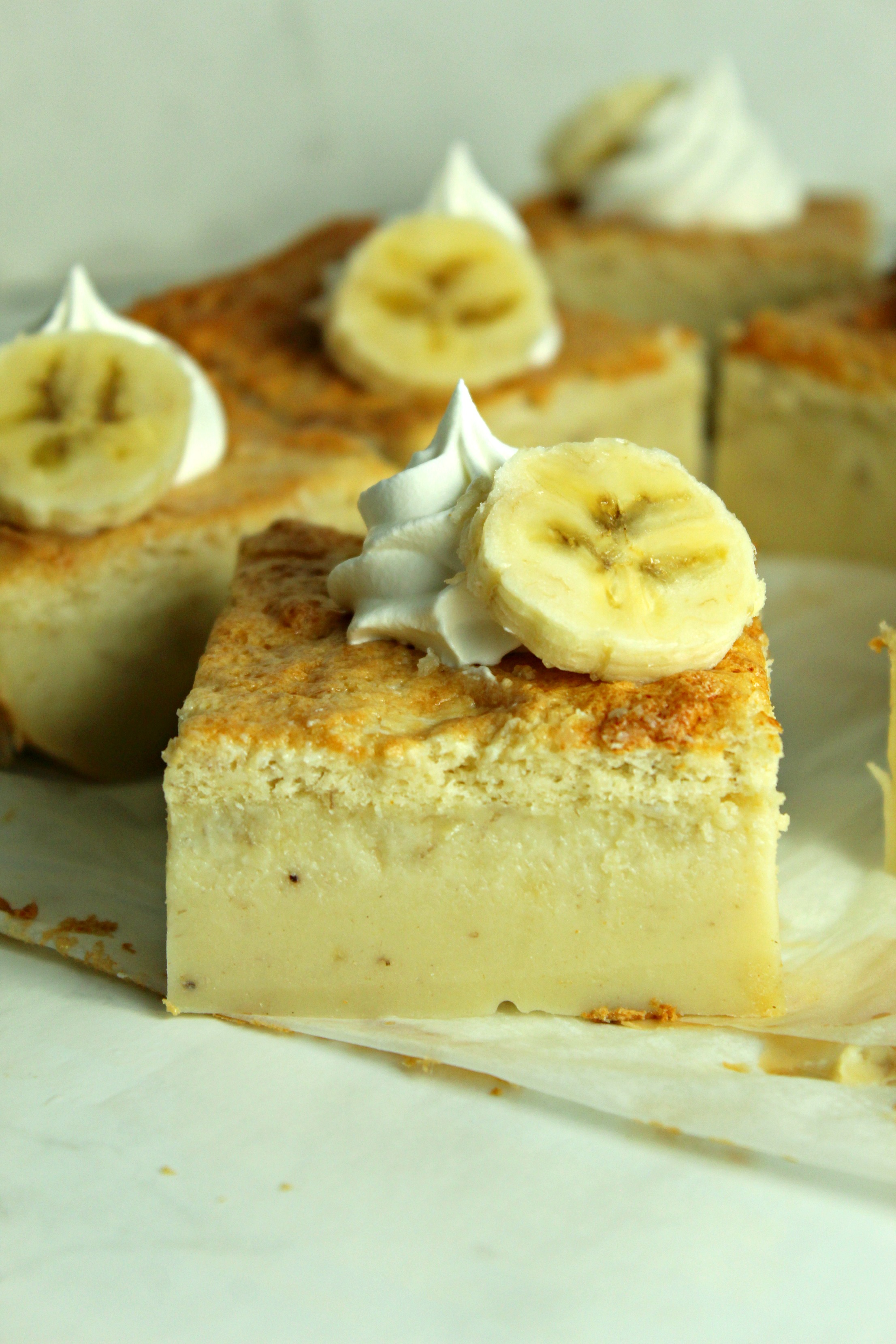 side view of Banana Magic Cake slice on parchment paper