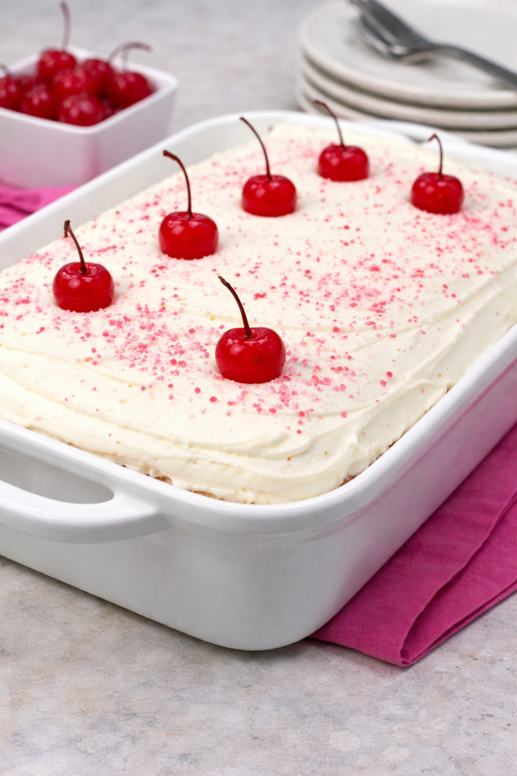 Very Cherry Cake with Vanilla Buttercream in a white baking dish uncut