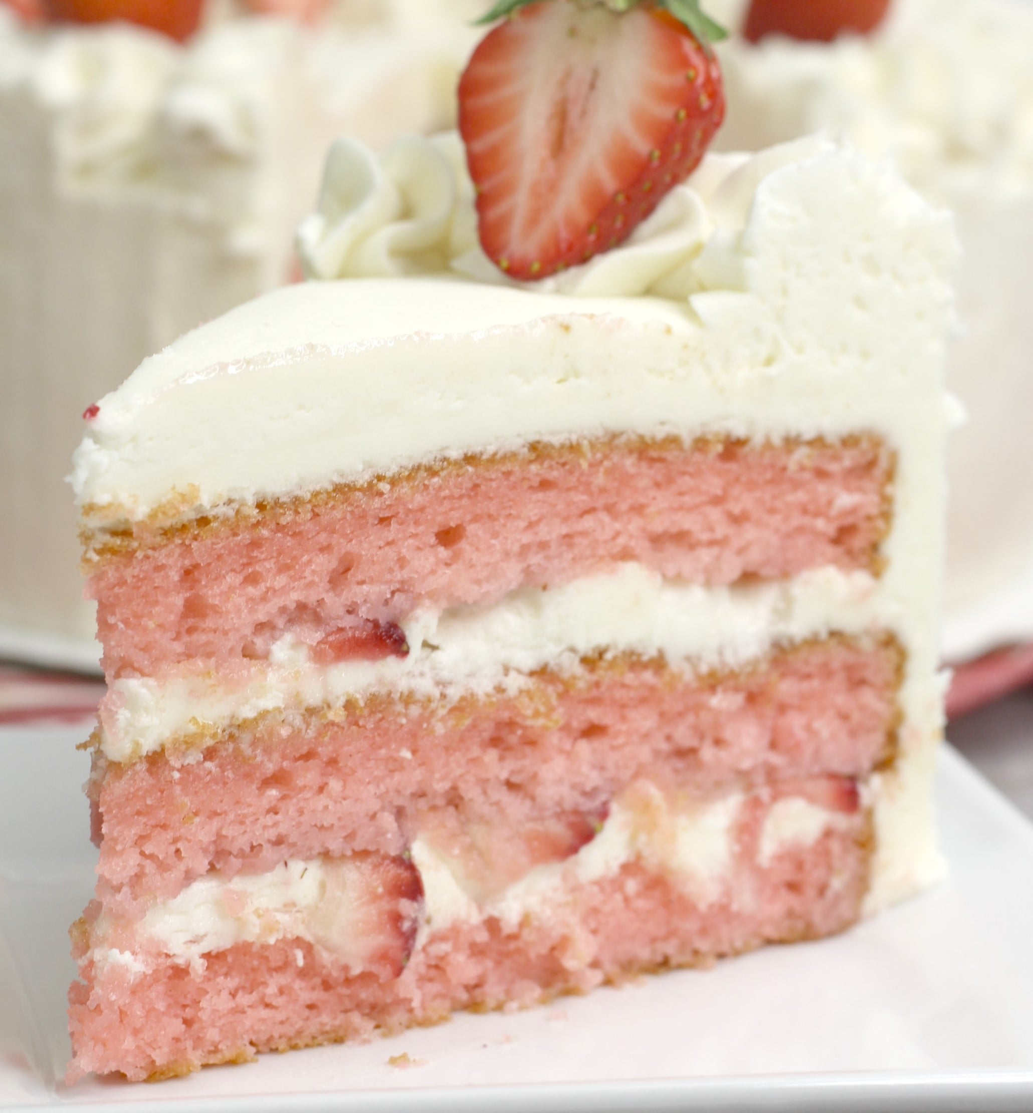 Strawberry Moscato Cake with Cream Cheese Buttercream Frosting on a white plate 