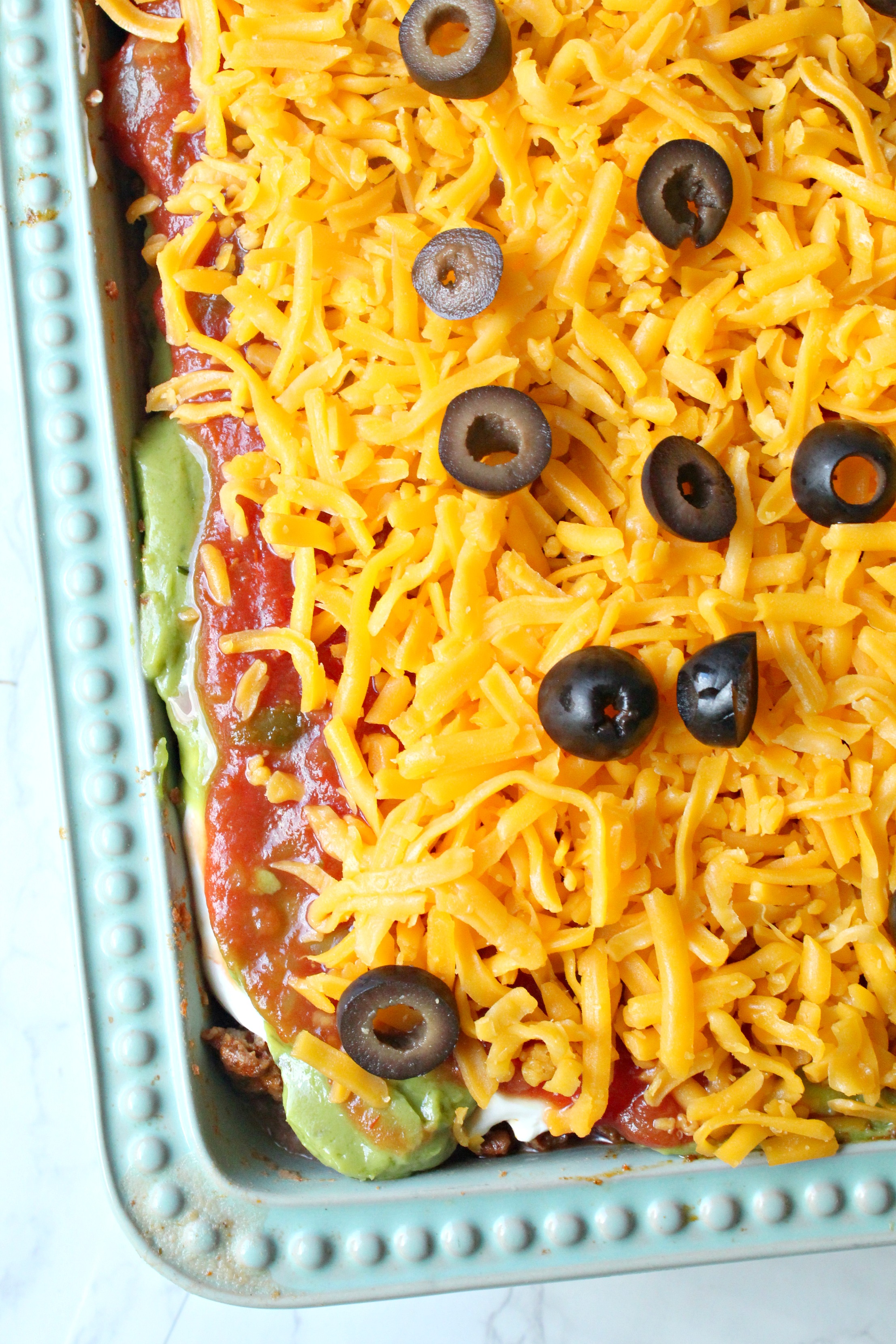 7 layer taco dip overhead shot in a blue baking dish