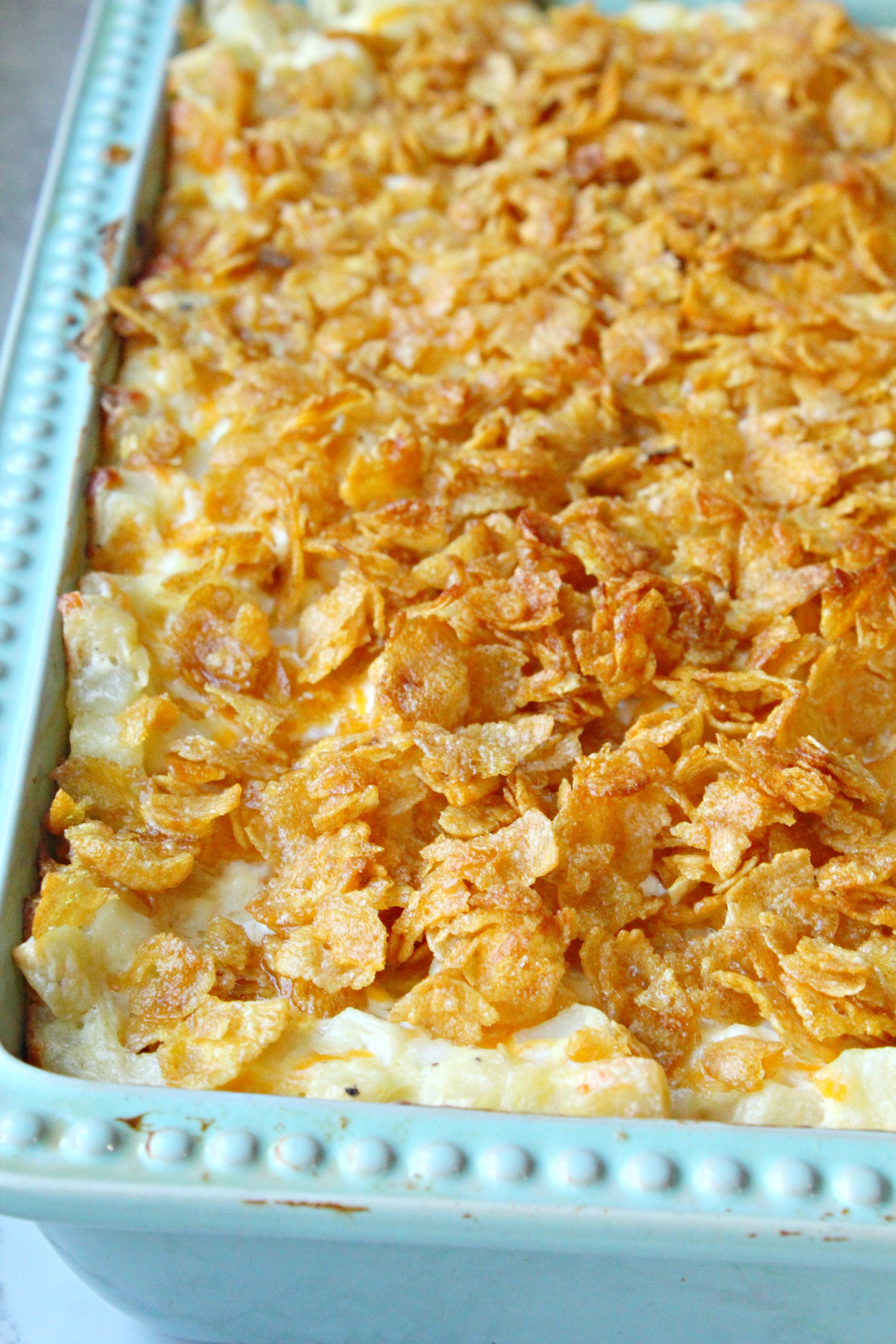 Funeral Potatoes in a baking pan with flakes on top