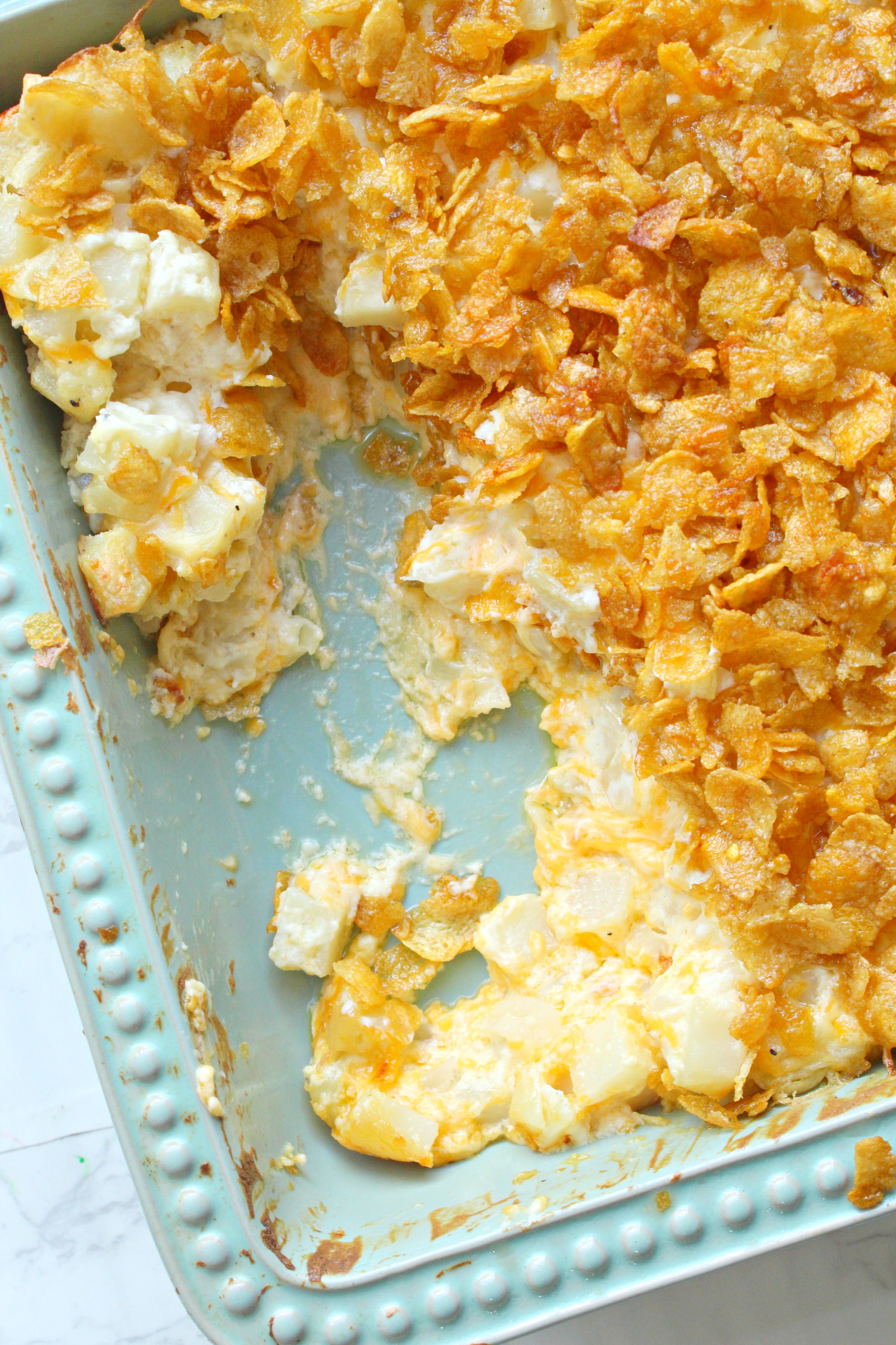 Funeral Potatoes in a baking pan with some missing