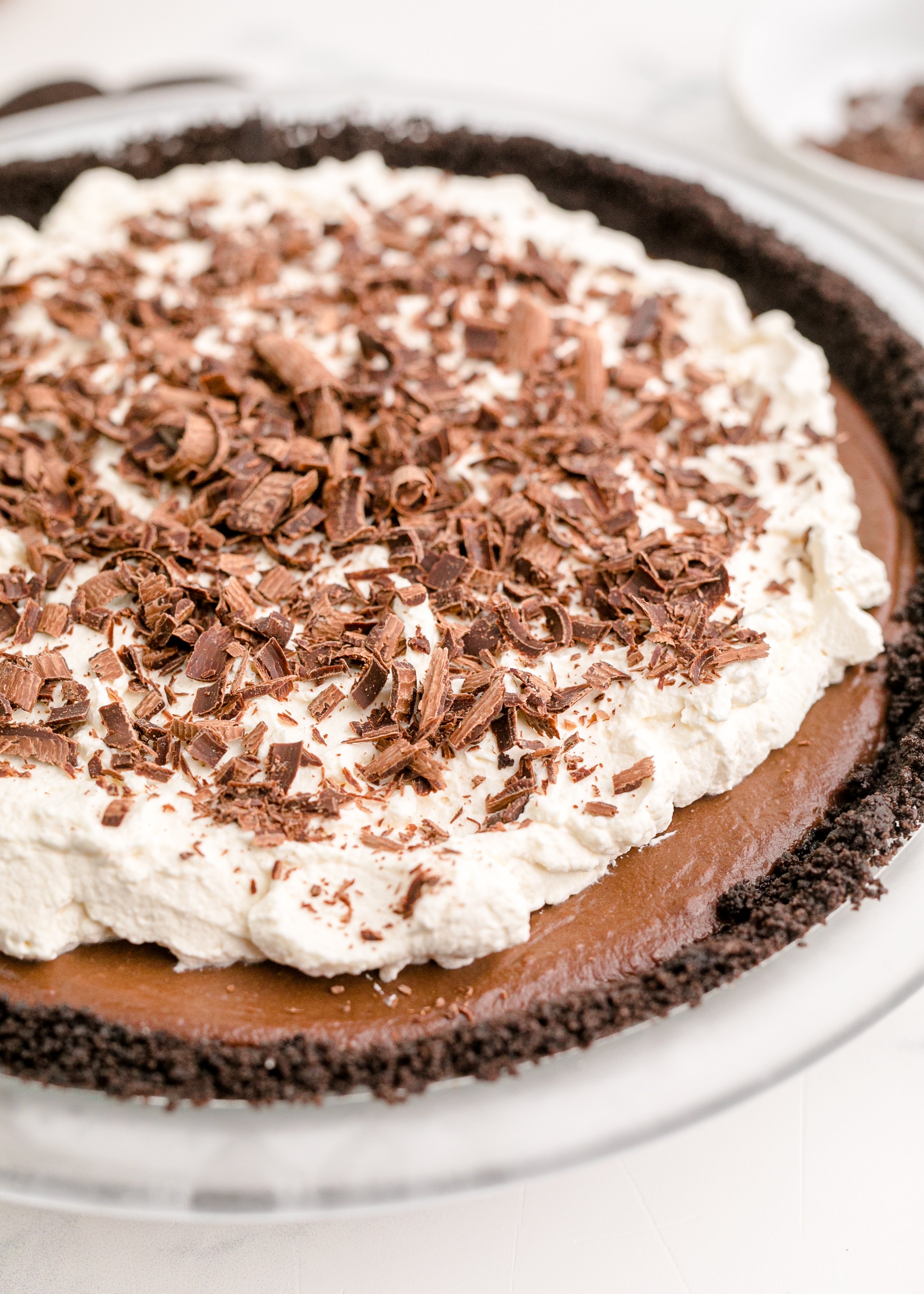 Chocolate Cream Pie topped with real whipped cream and sprinkled with chocolate shavings slide angle
