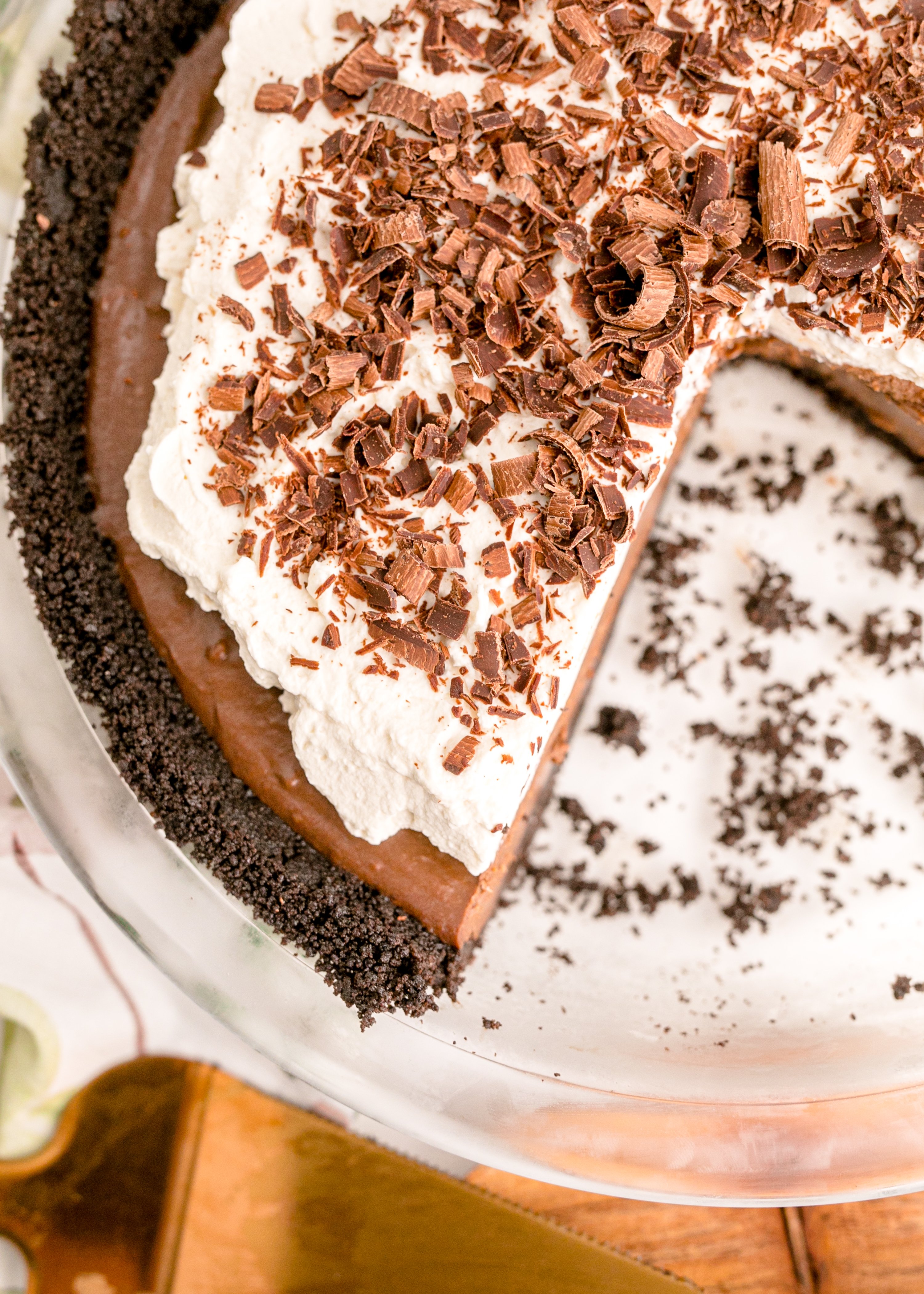 Chocolate Cream Pie topped with whipped cream and chocolate shavings in a white pie dish overhead shot