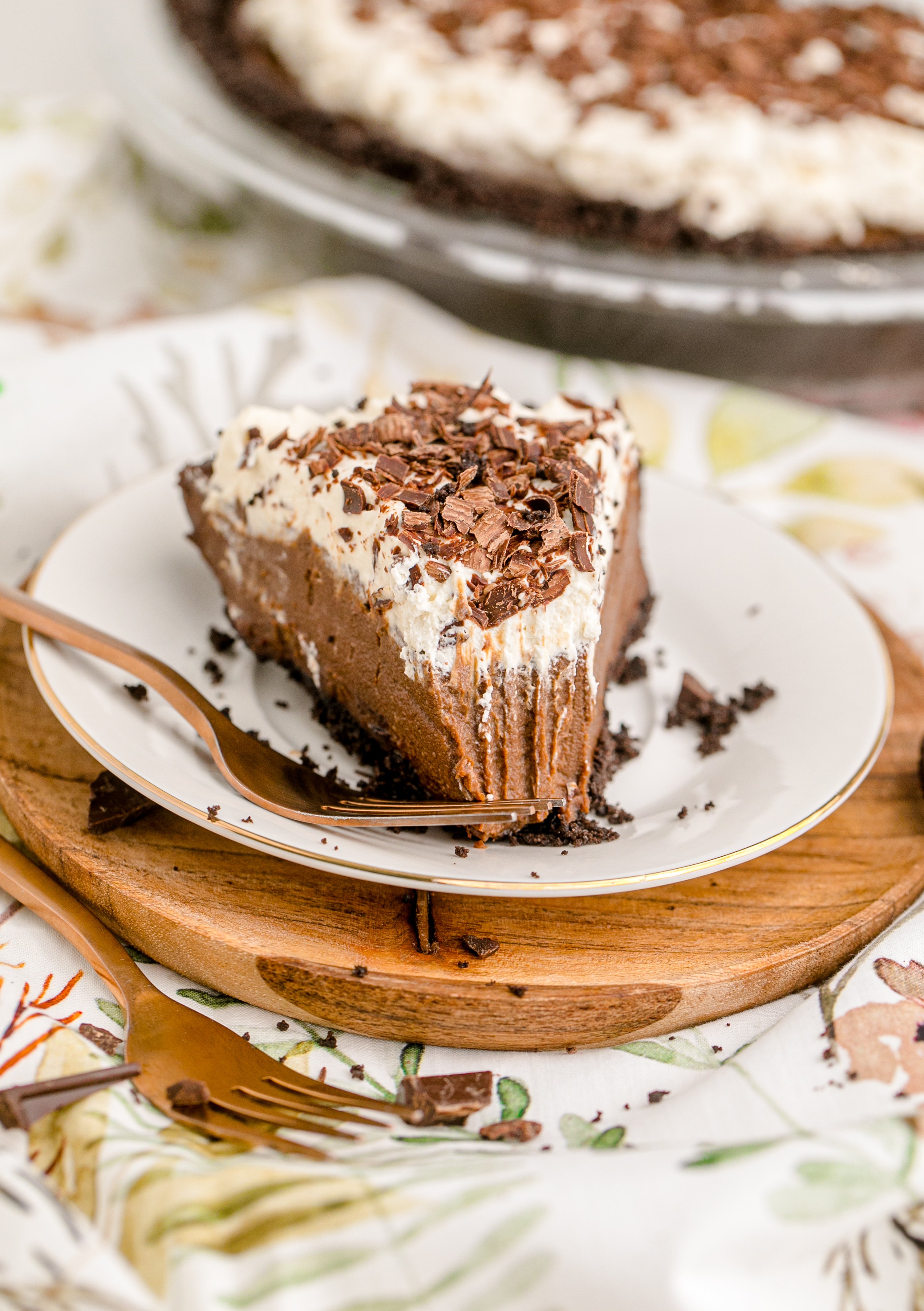 Chocolate Cream Pie topped with whipped cream and chocolate shavings on a white plate