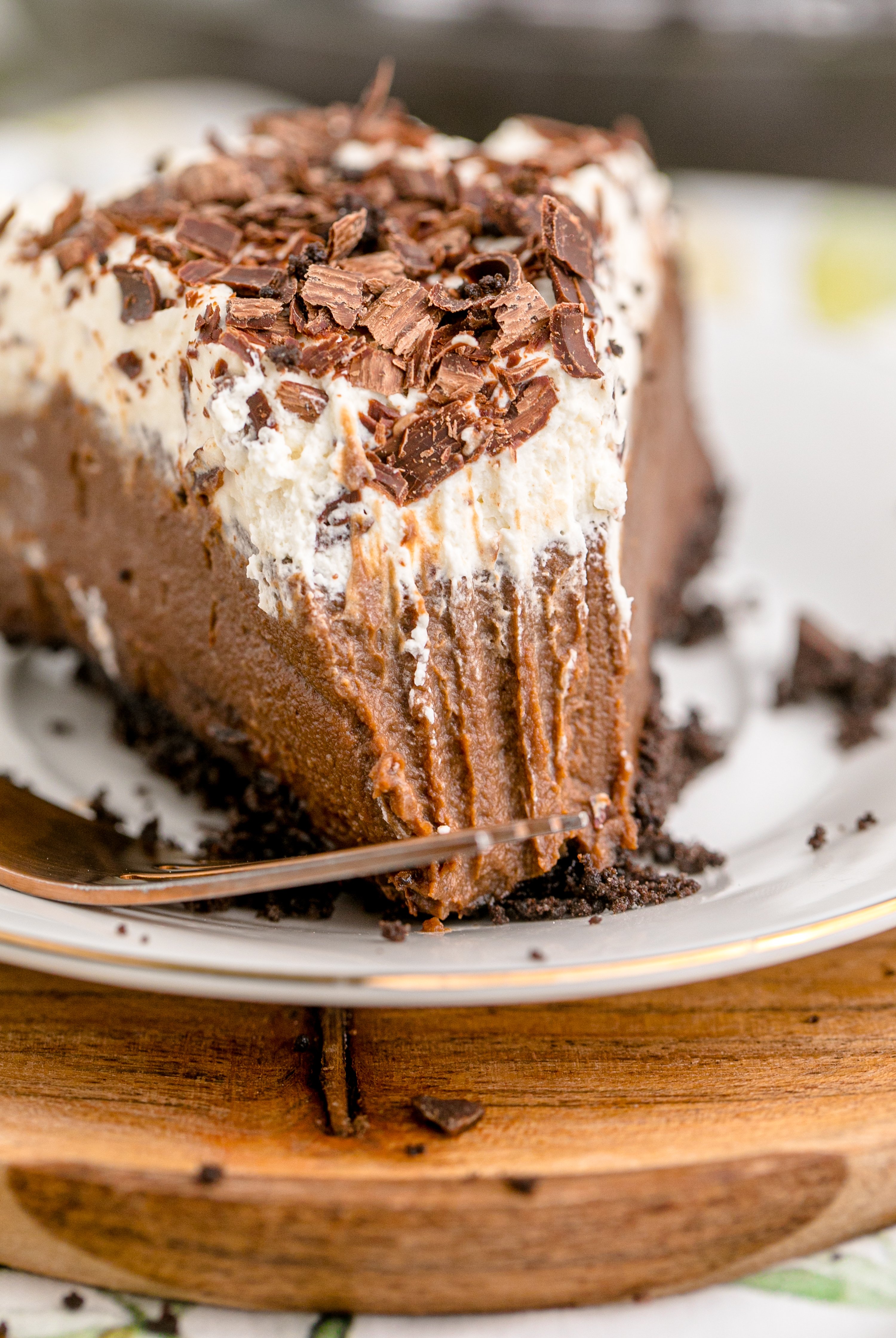 Chocolate Cream Pie topped with whipped cream and chocolate shavings on a white plate