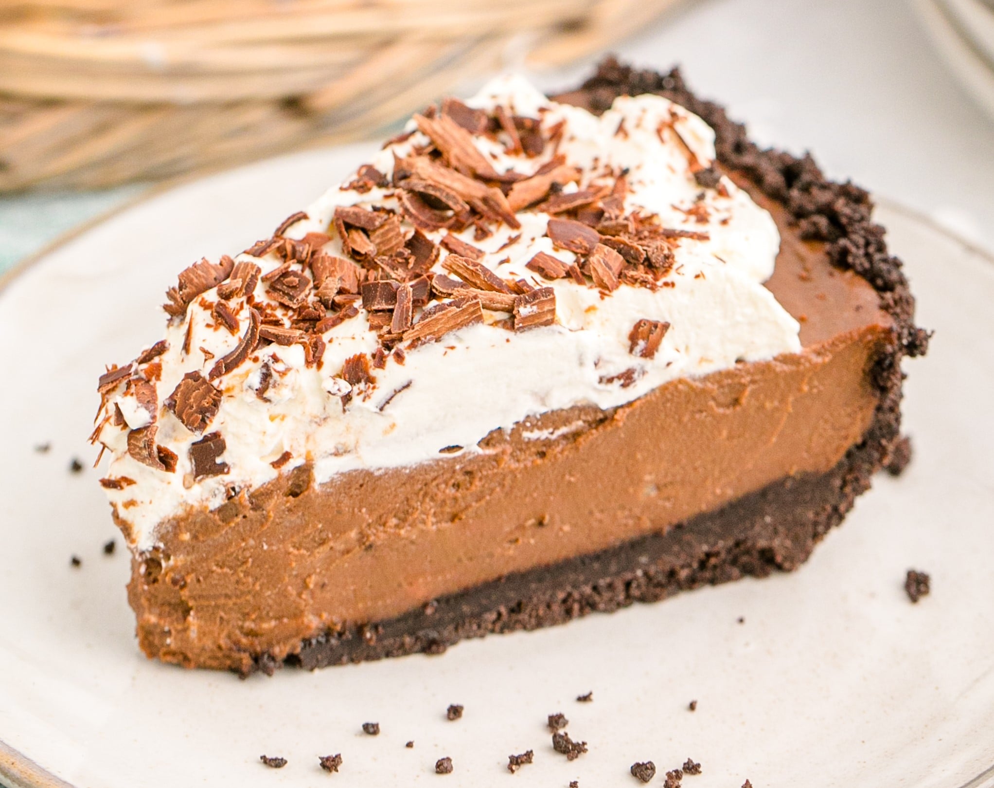 Chocolate Cream Pie topped with whipped cream and chocolate shavings on a white plate