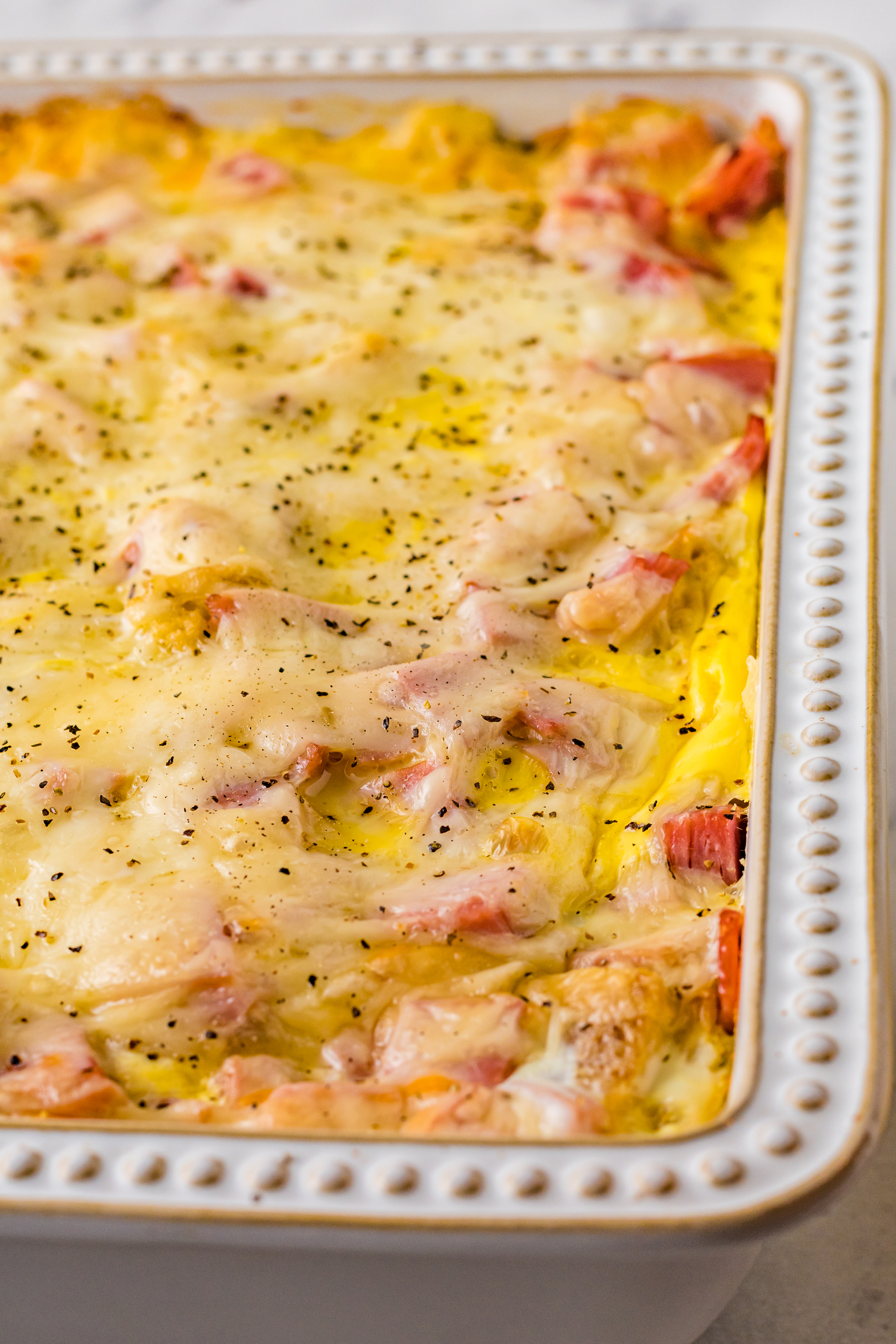 Eggs Benedict in a white casserole dish up close
