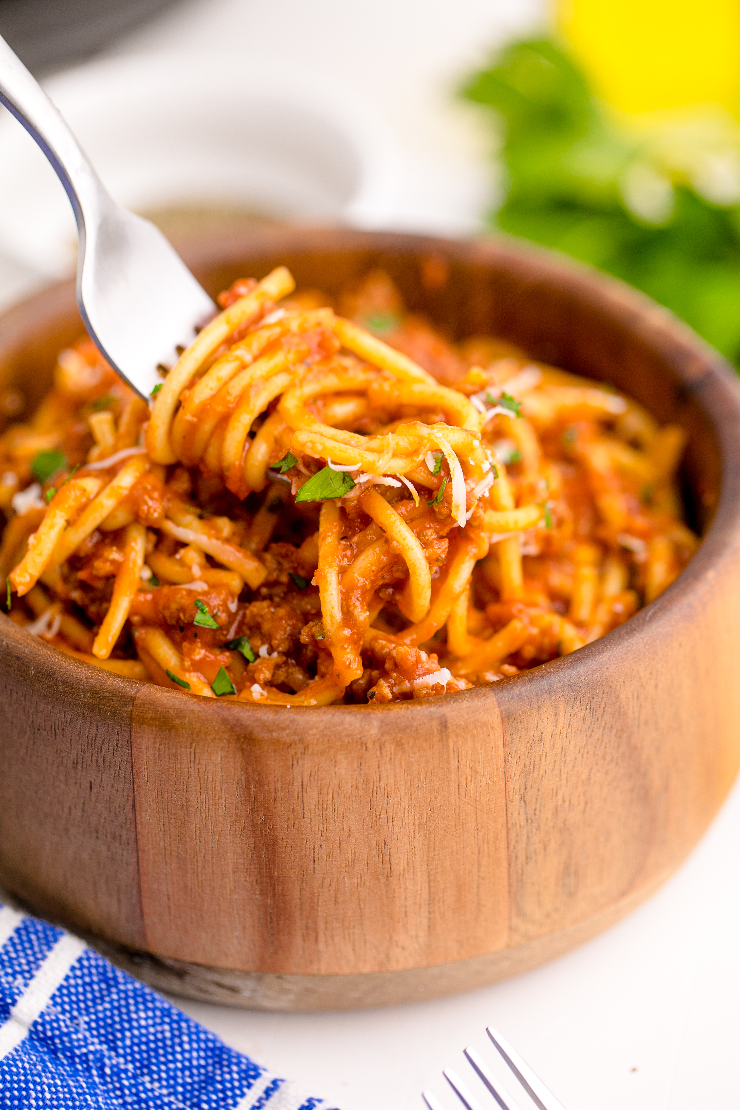 Instant Pot Spaghetti in a wooden bowl with a fork lifting the spaghetti up