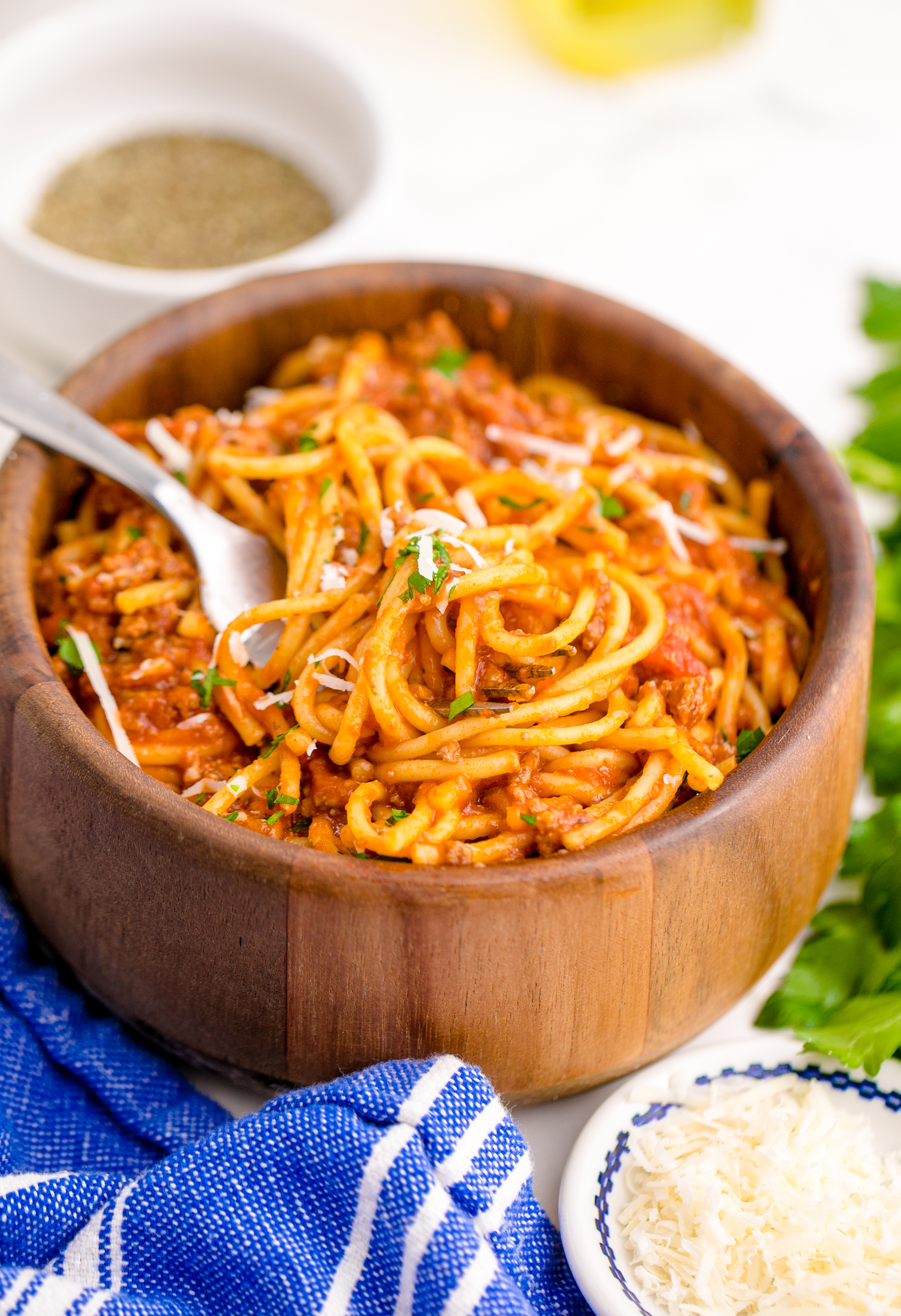 Instant Pot Spaghetti in a wooden bowl with a fork lifting the spaghetti up
