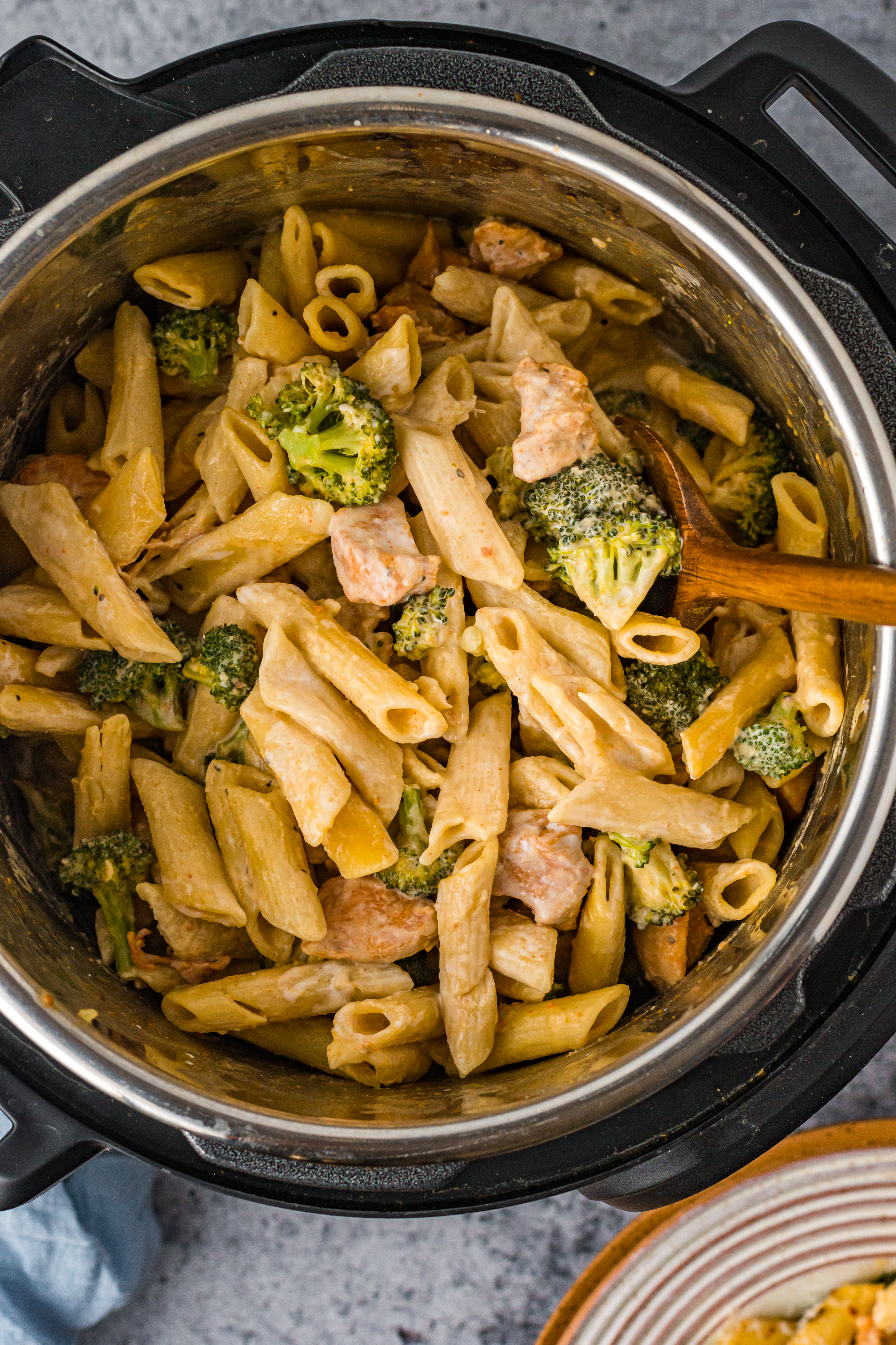 Chicken Pasta on a plate covered in cheese in the instant pot with broccoli