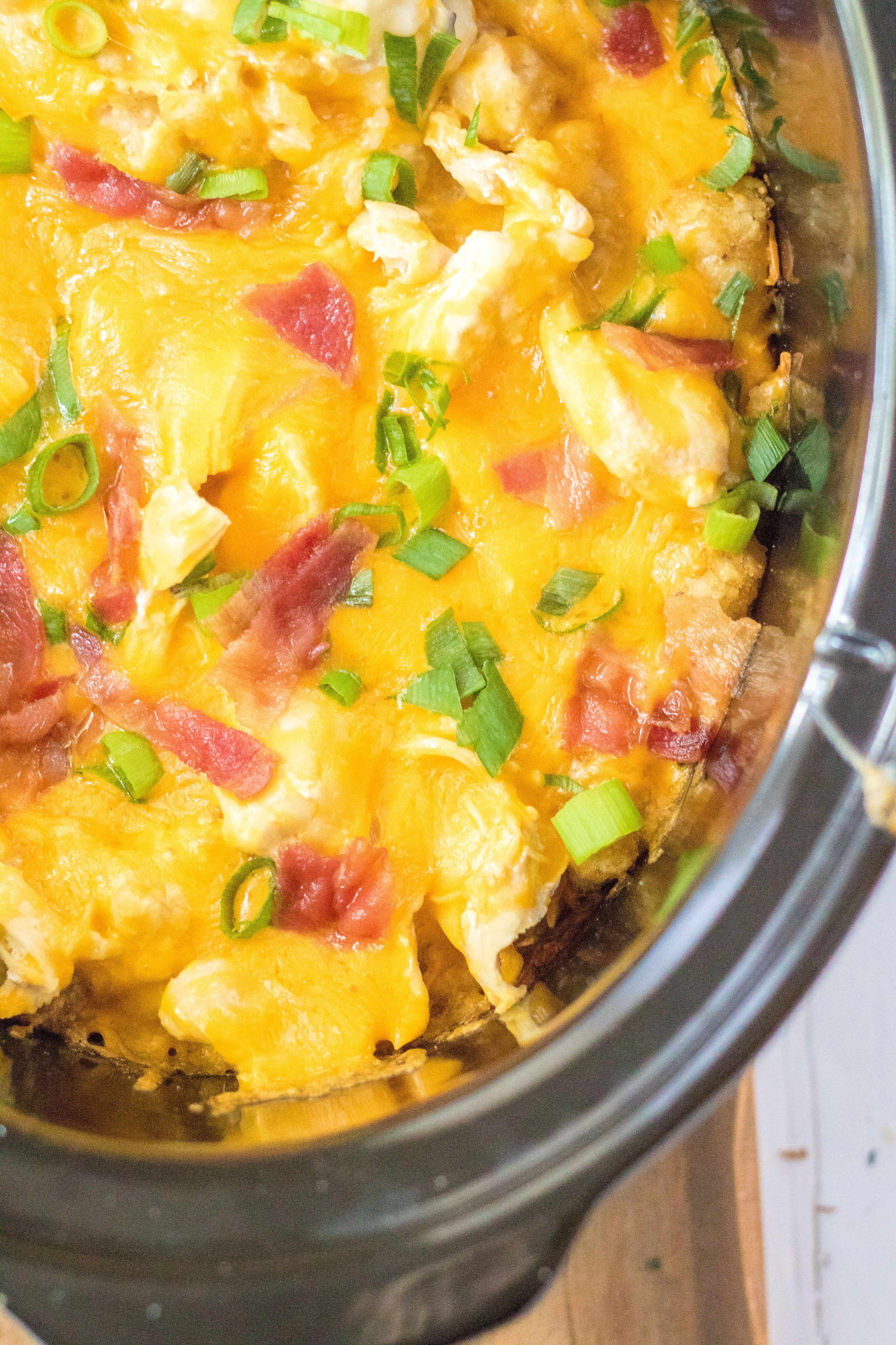 Tater Tot Casserole in the crock pot covered in melty cheese