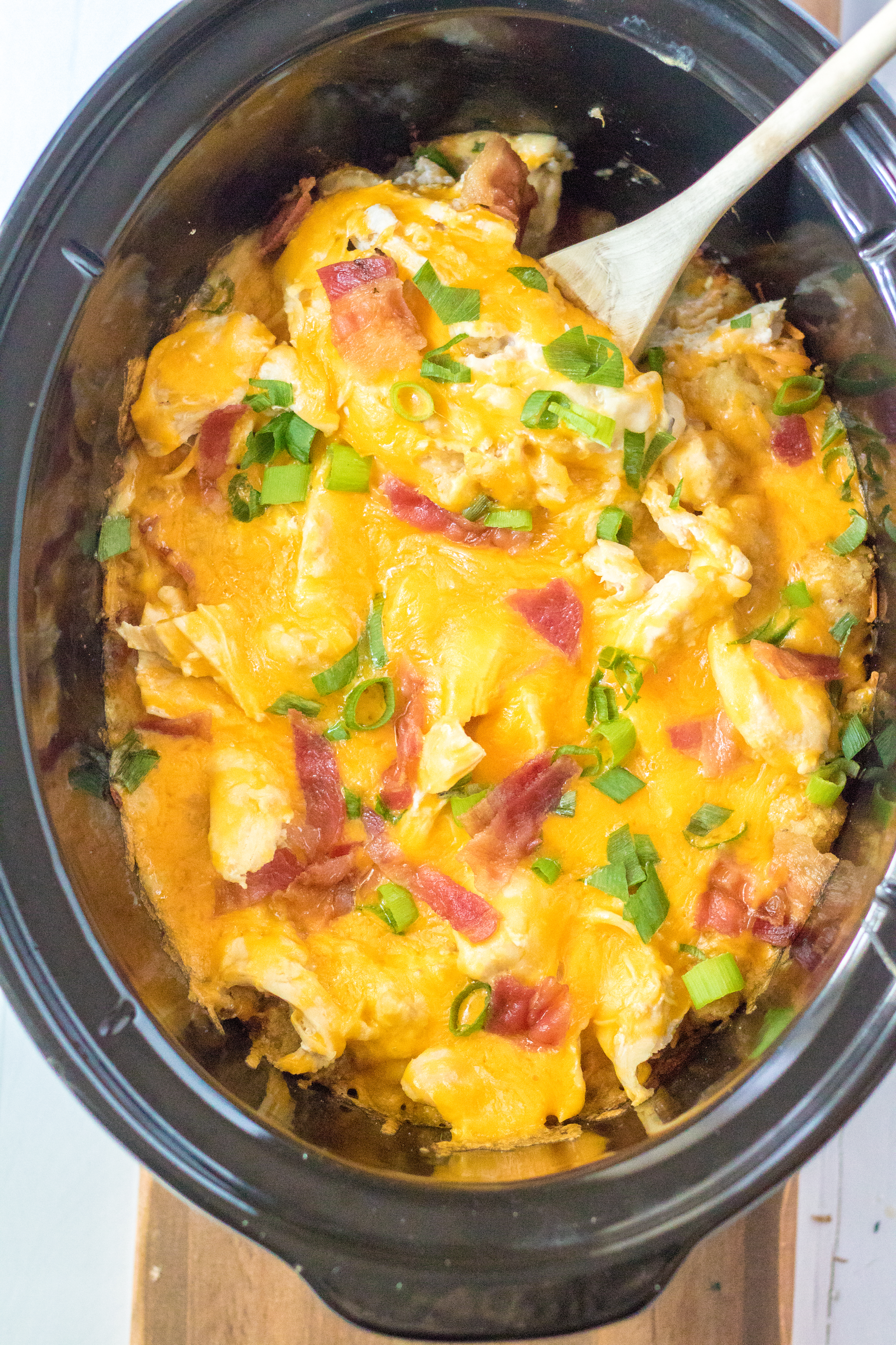 Tater Tot Casserole in the crock pot with a spoon in it