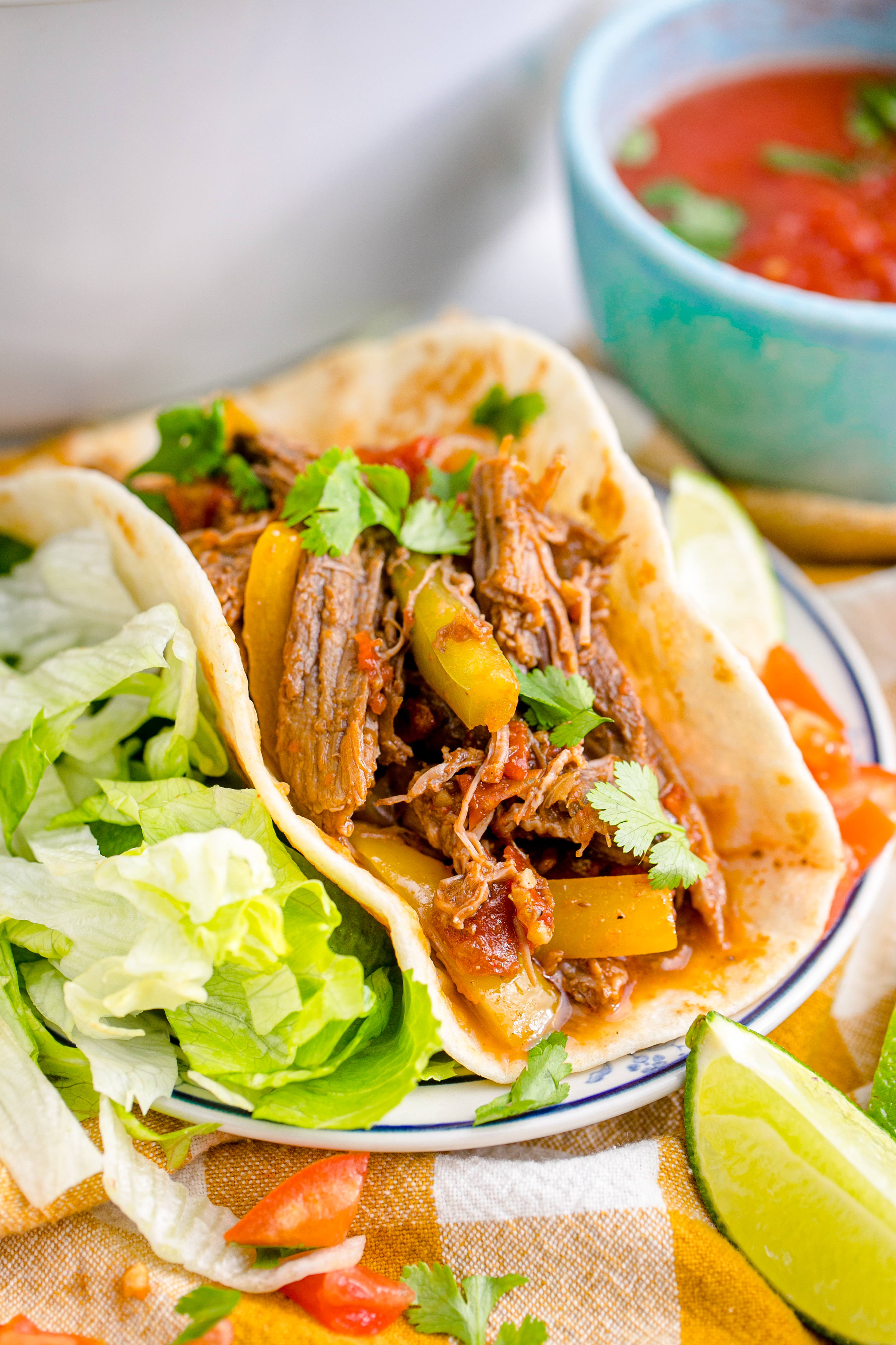 Steak Fajitas wrapped in a tortilla with lettuce piled next to it