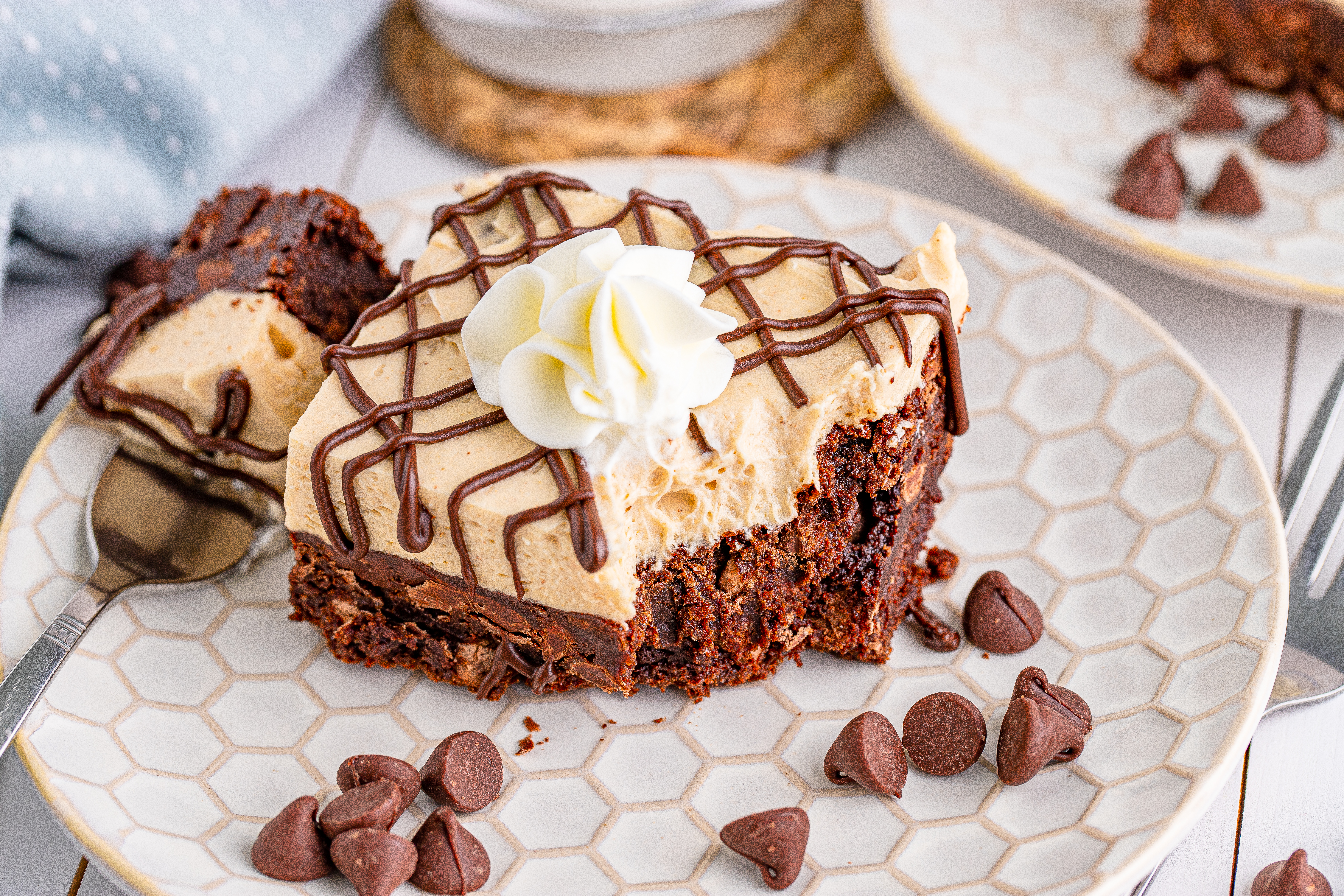 Peanut Butter Brownies on a white place drizzeled with chocolate and topped with whipped cream