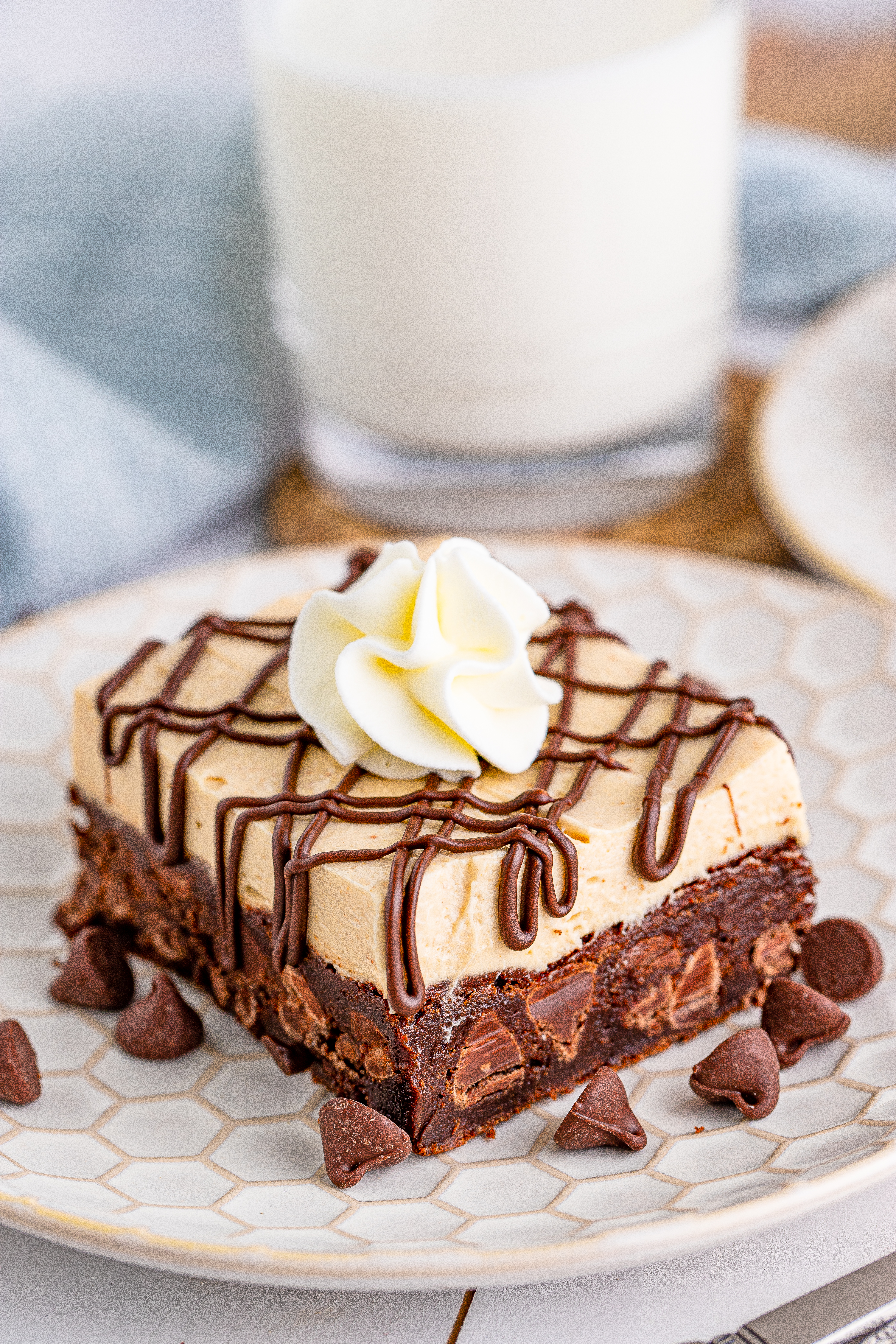 Peanut Butter Brownies on a white place drizzled with chocolate and topped with whipped cream