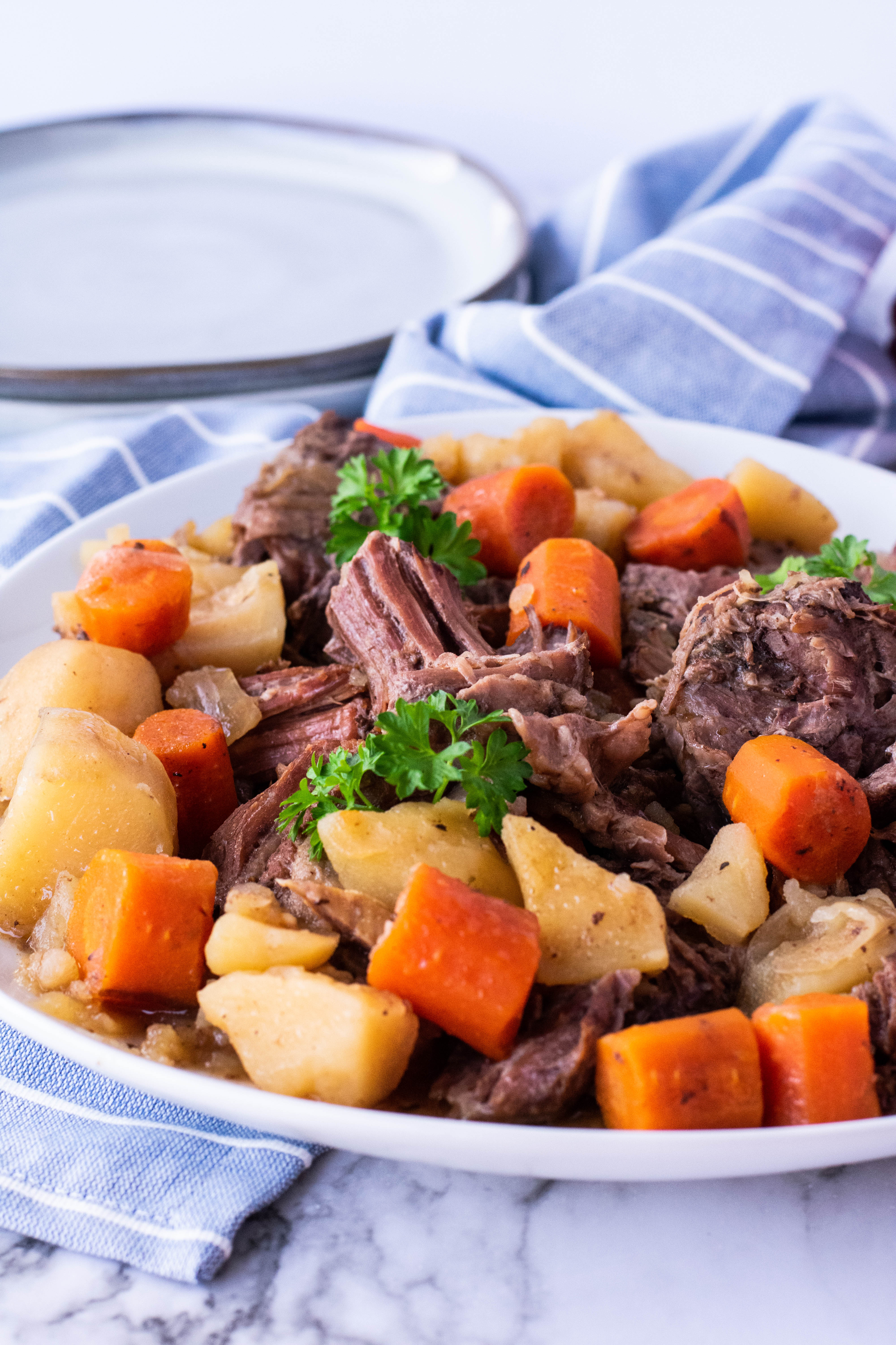 crock pot chuck roast on a plate with potatoes and carrots