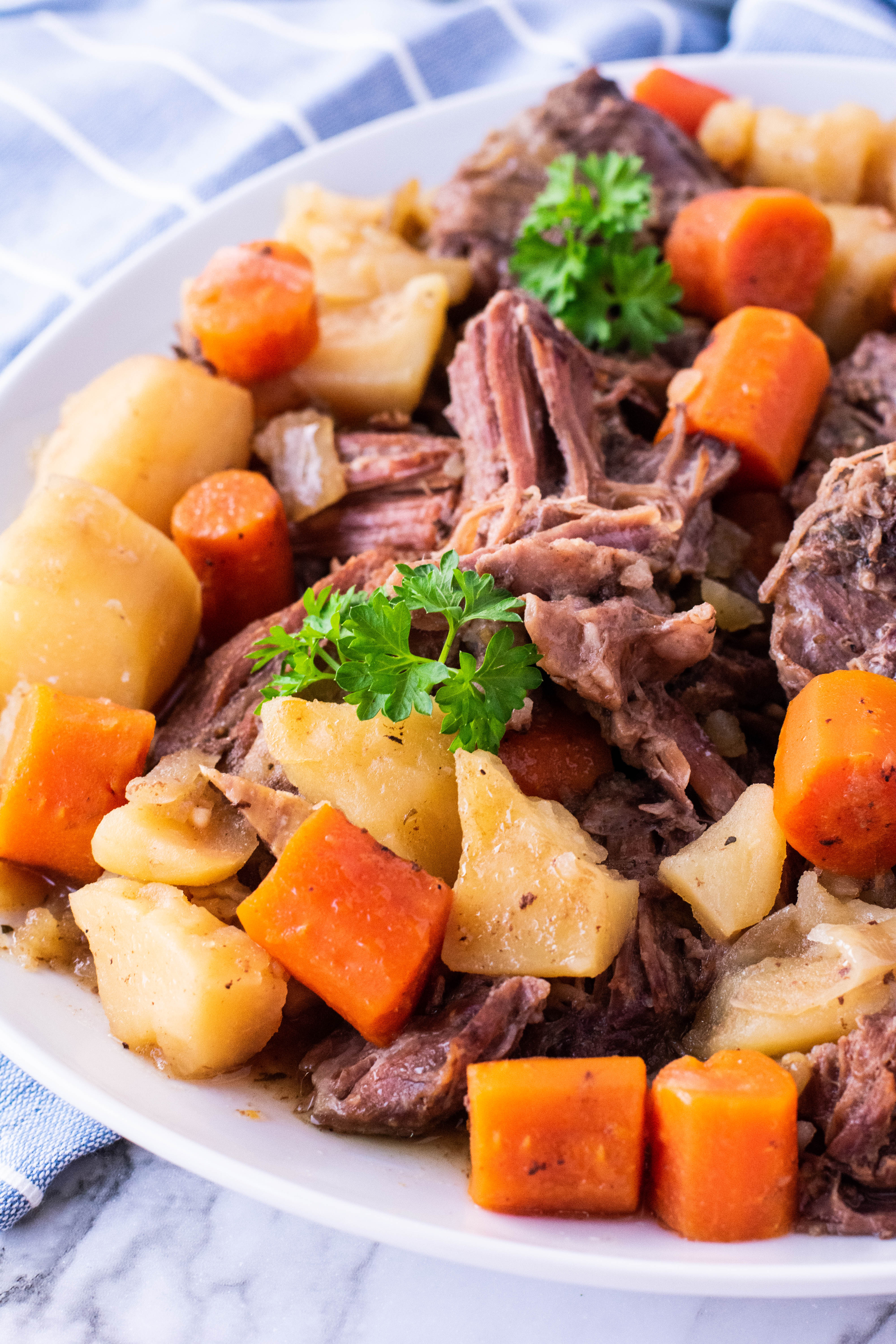 crock pot chuck roast on a plate with potatoes and carrots