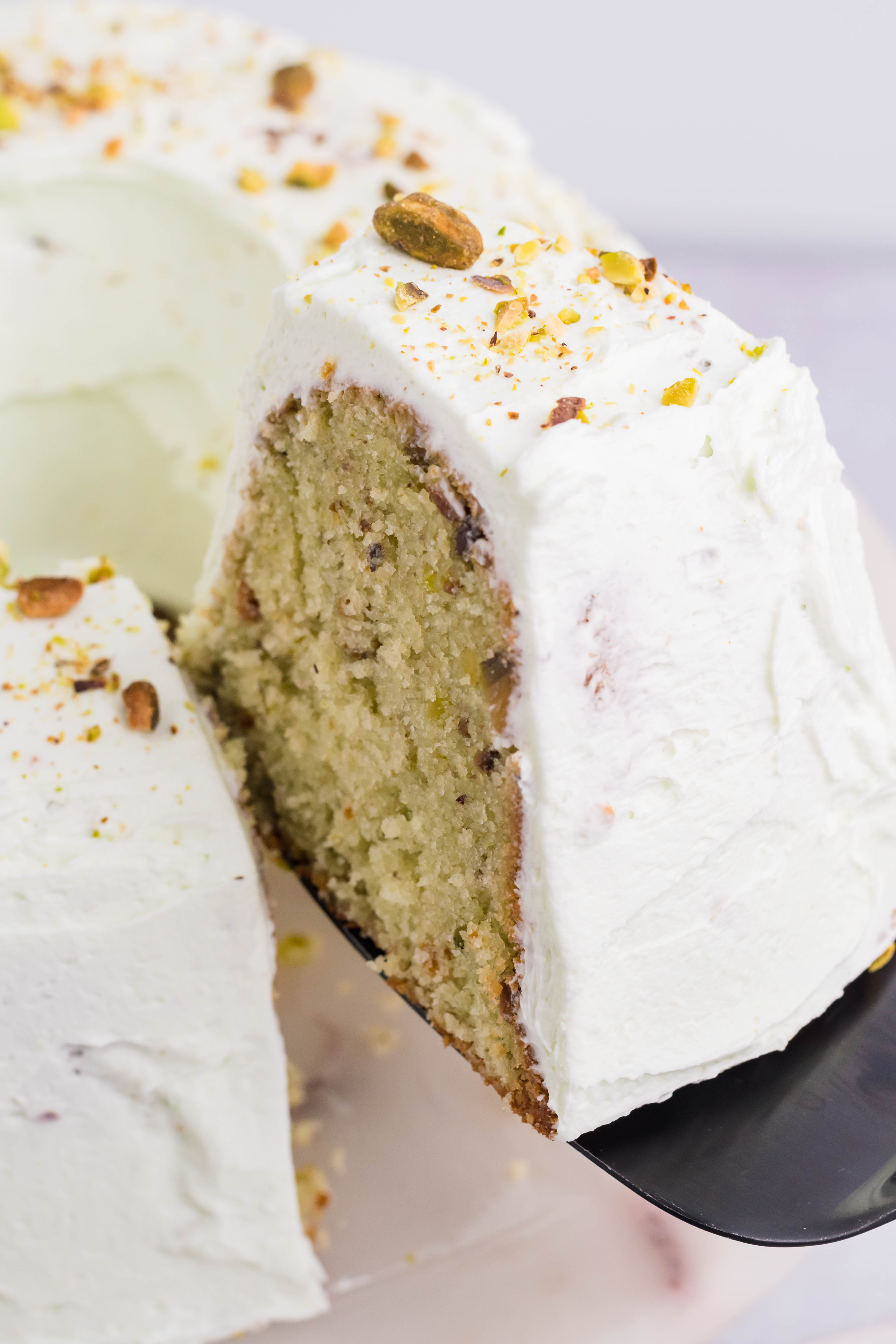 Pistachio Cake slice being lifted on a spatula