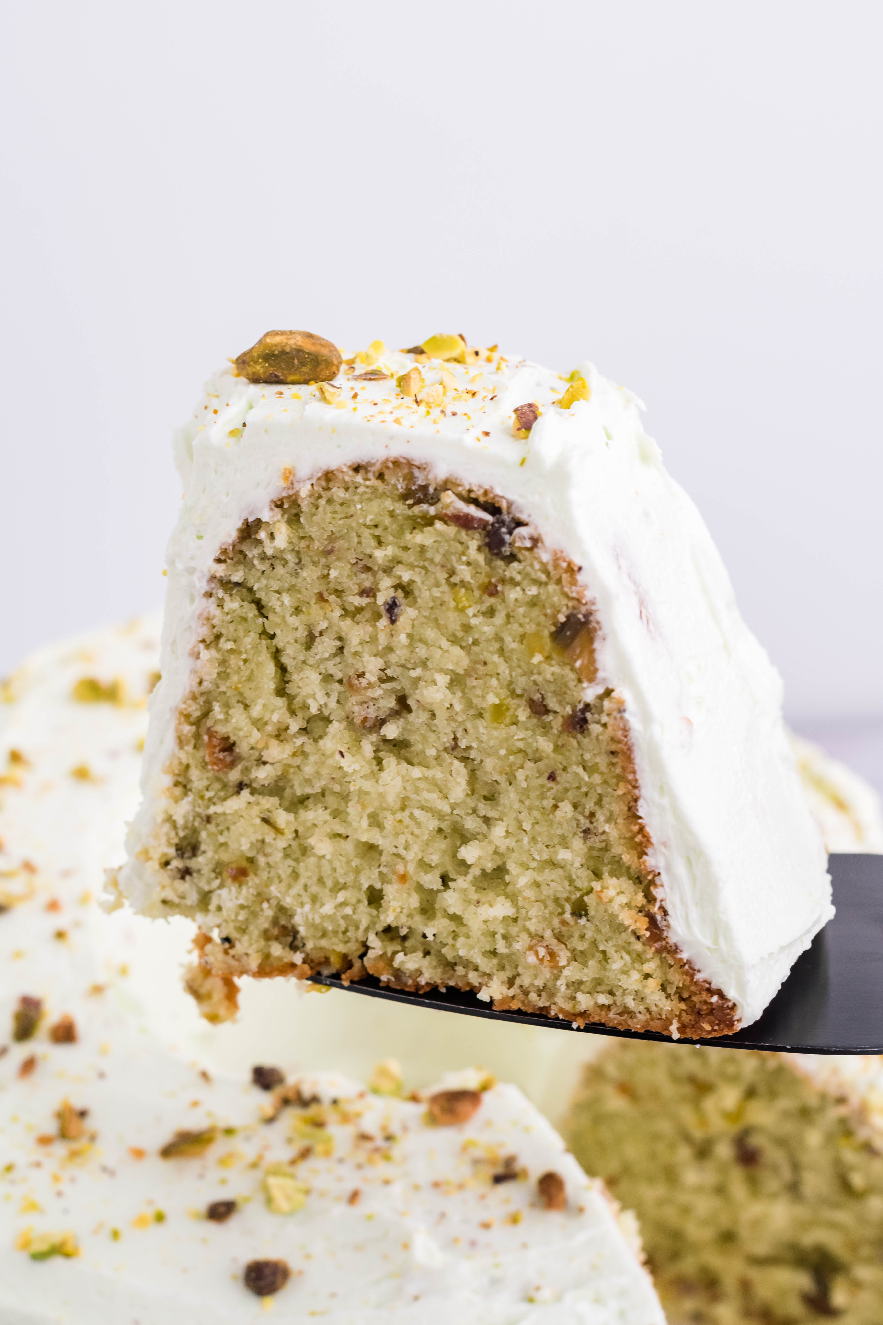 Pistachio Cake slice being lifted on a spatula