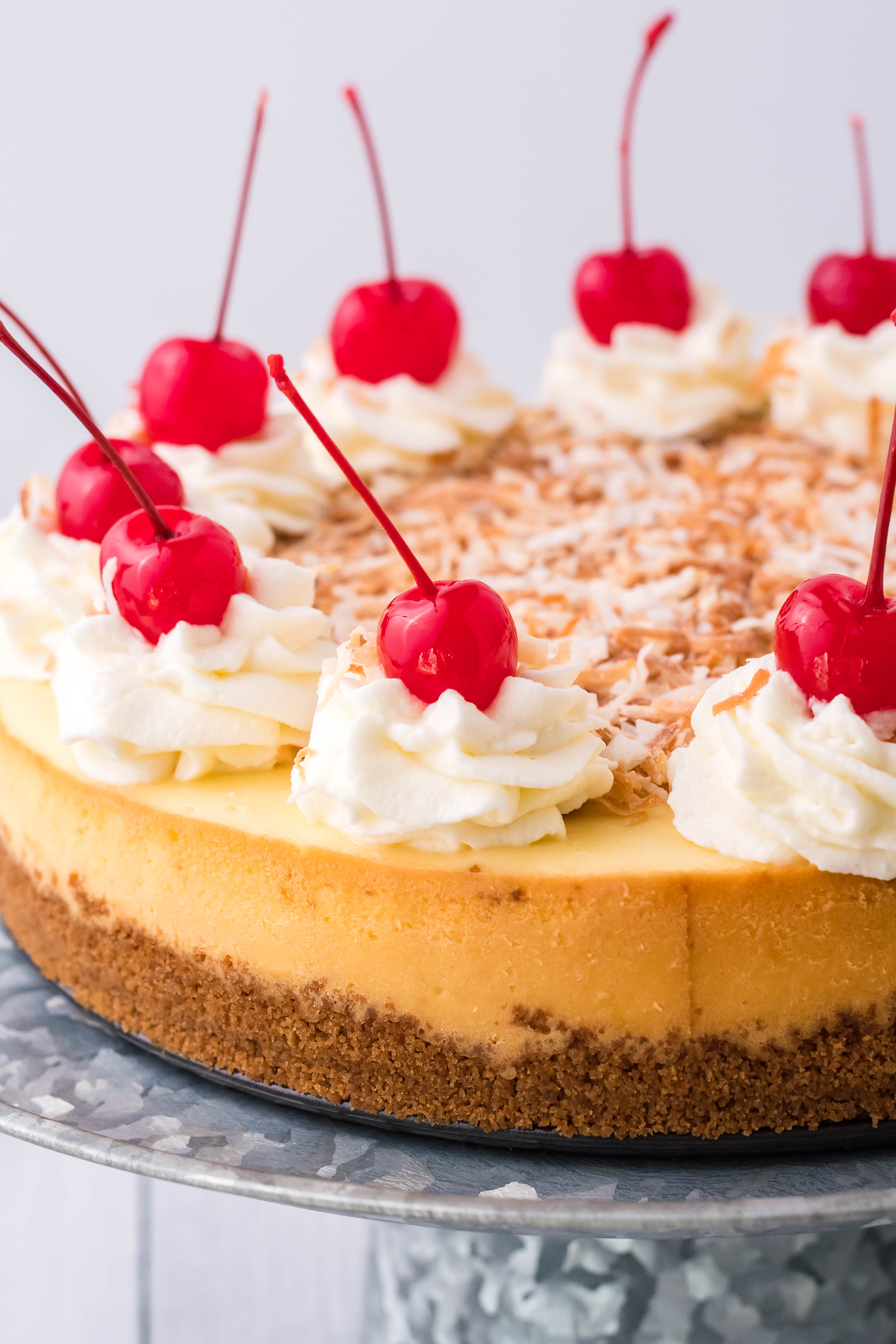 Coconut Cheesecake on a silver cake dish side shot