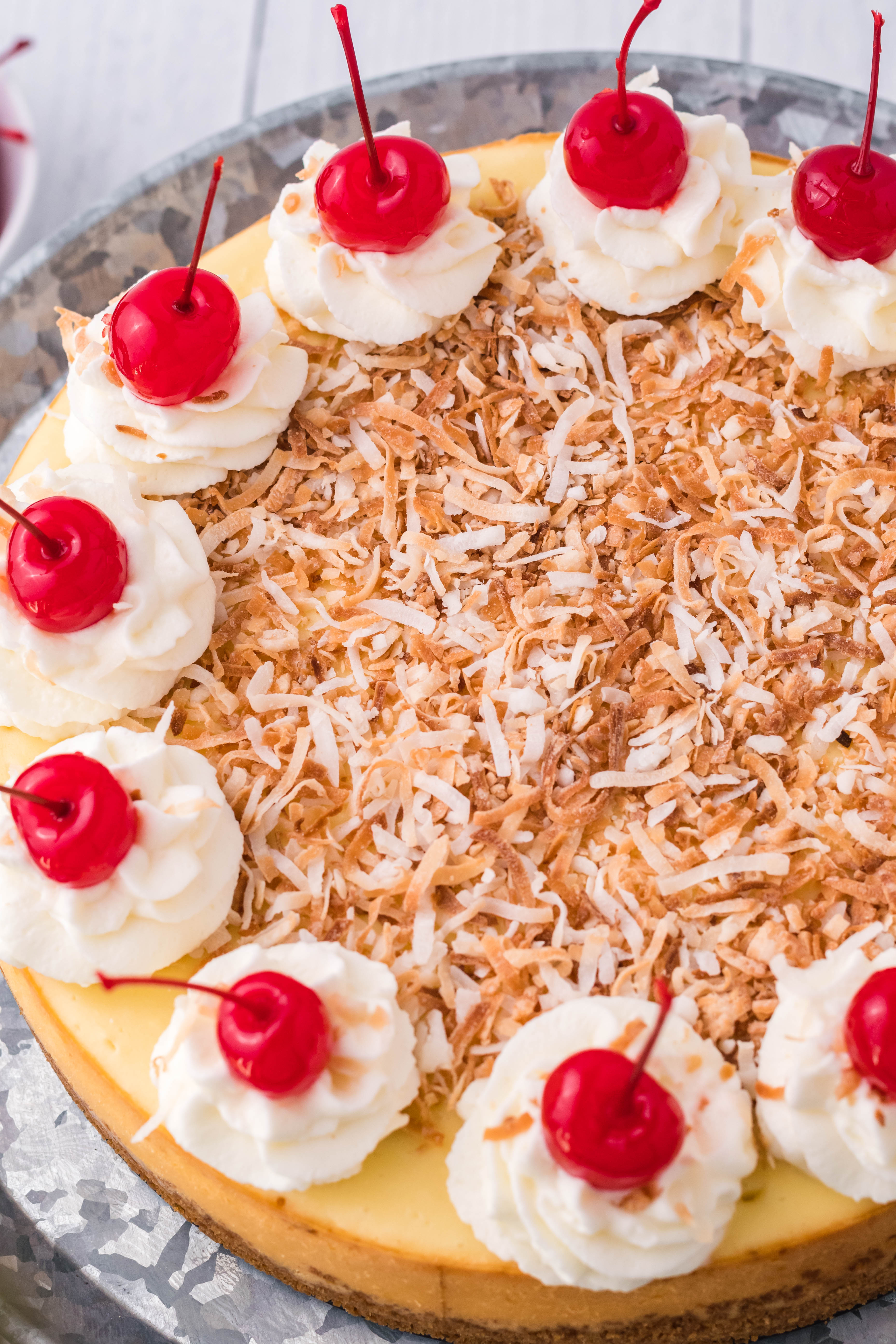 Coconut Cheesecake on a silver cake dish overhead shot