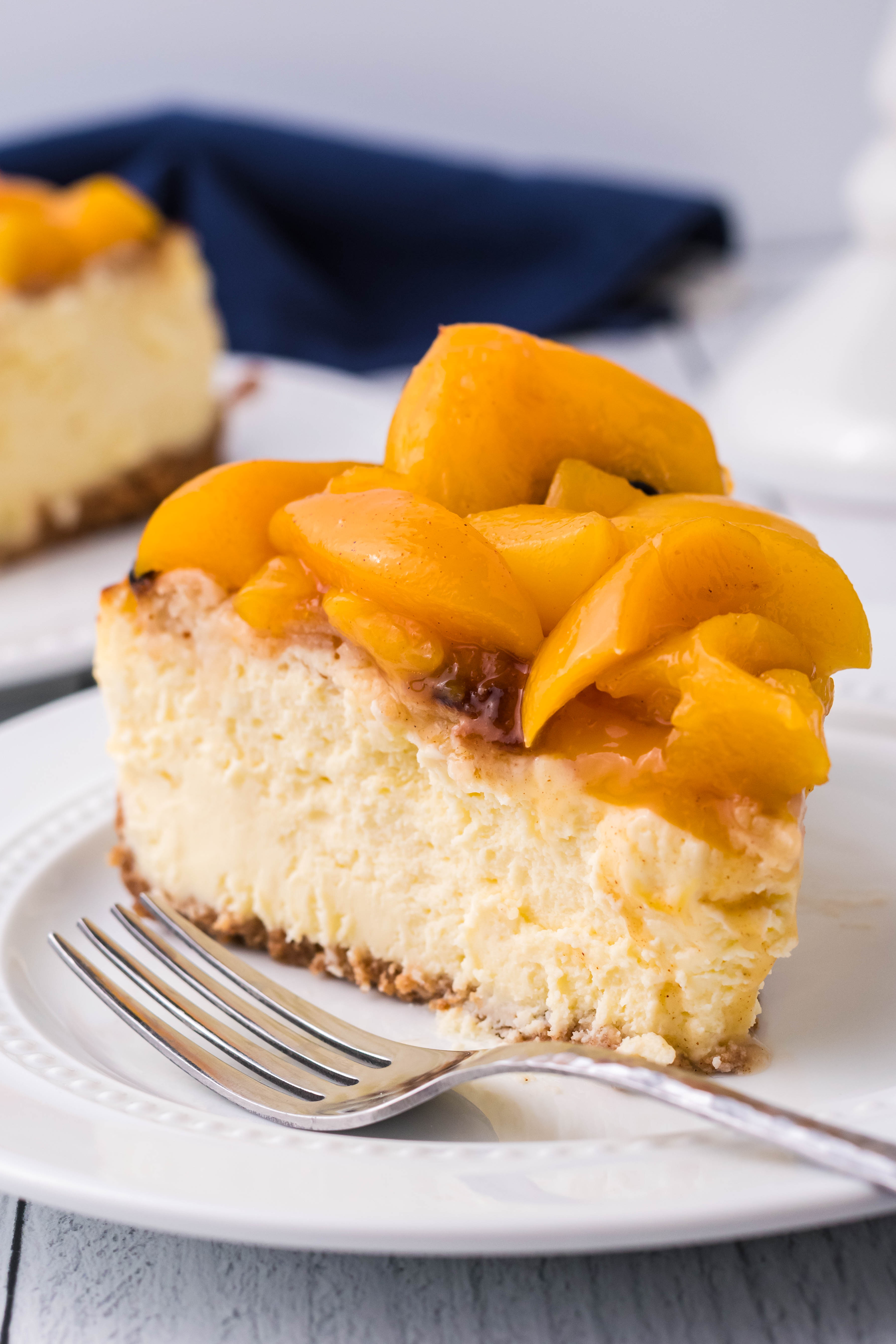 Peach Cobbler Cheesecake on a white plate side angle