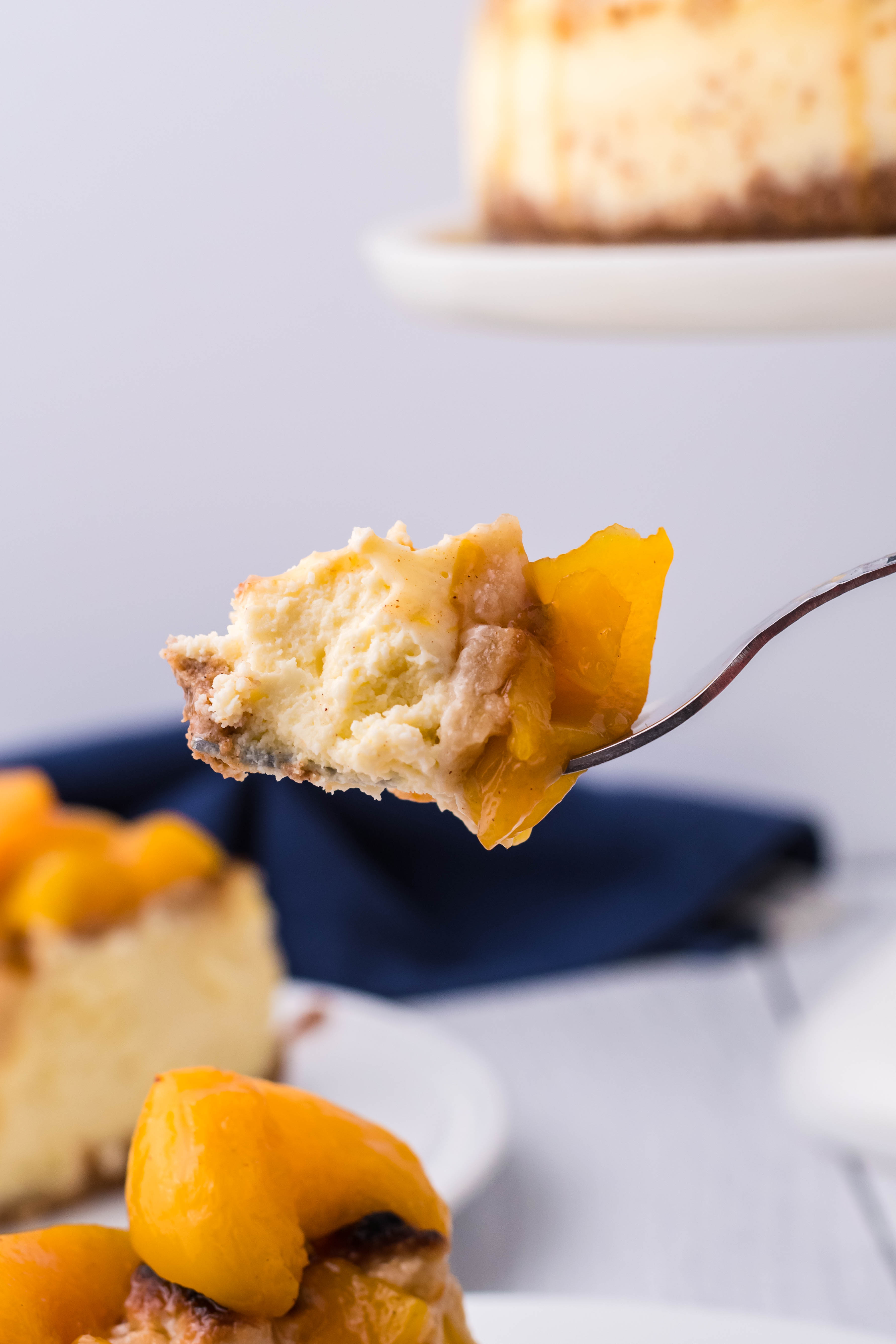 Peach Cobbler Cheesecake bite being held up on a fork