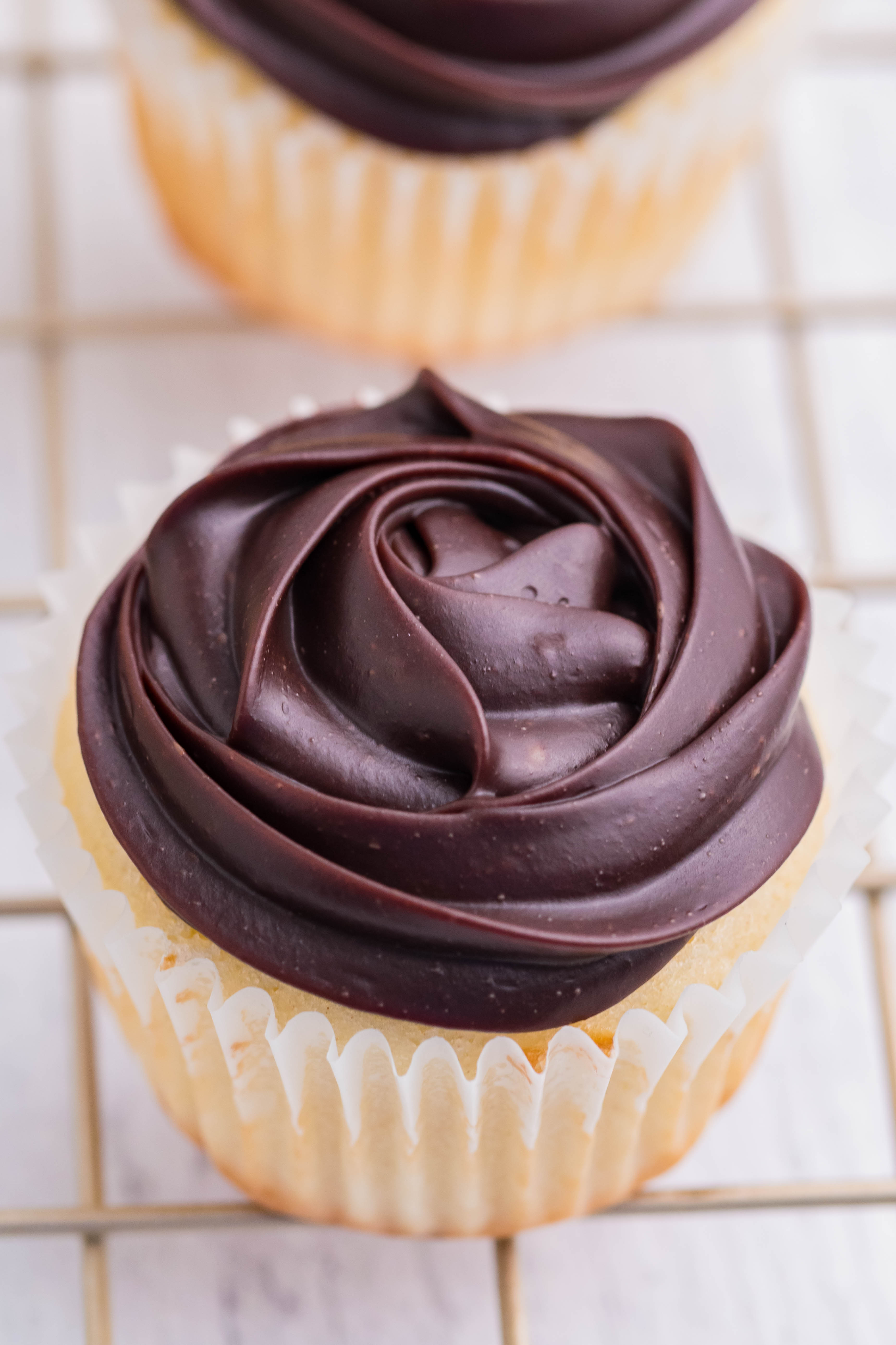 overhead shot of Boston Cream Cupcakes on a cooling metal rack