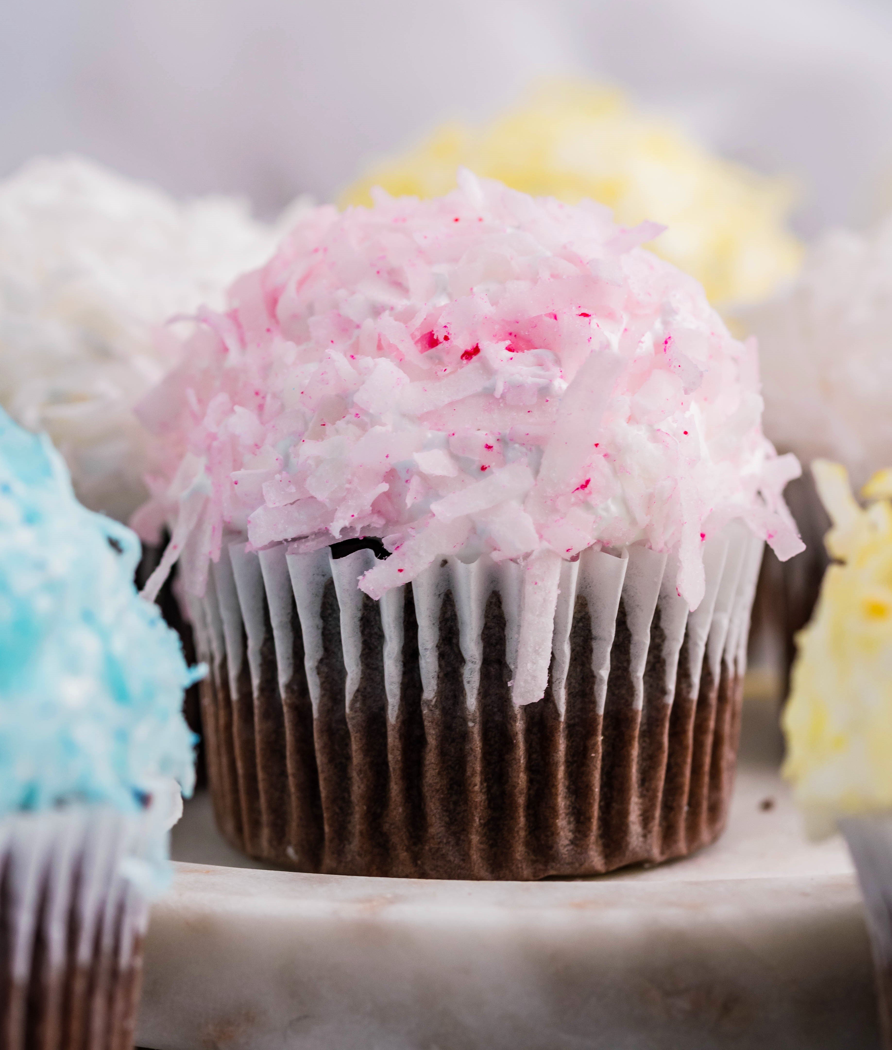 chocolate cupcake with pink coconut shavings & marshmallow frosting on a marble platter