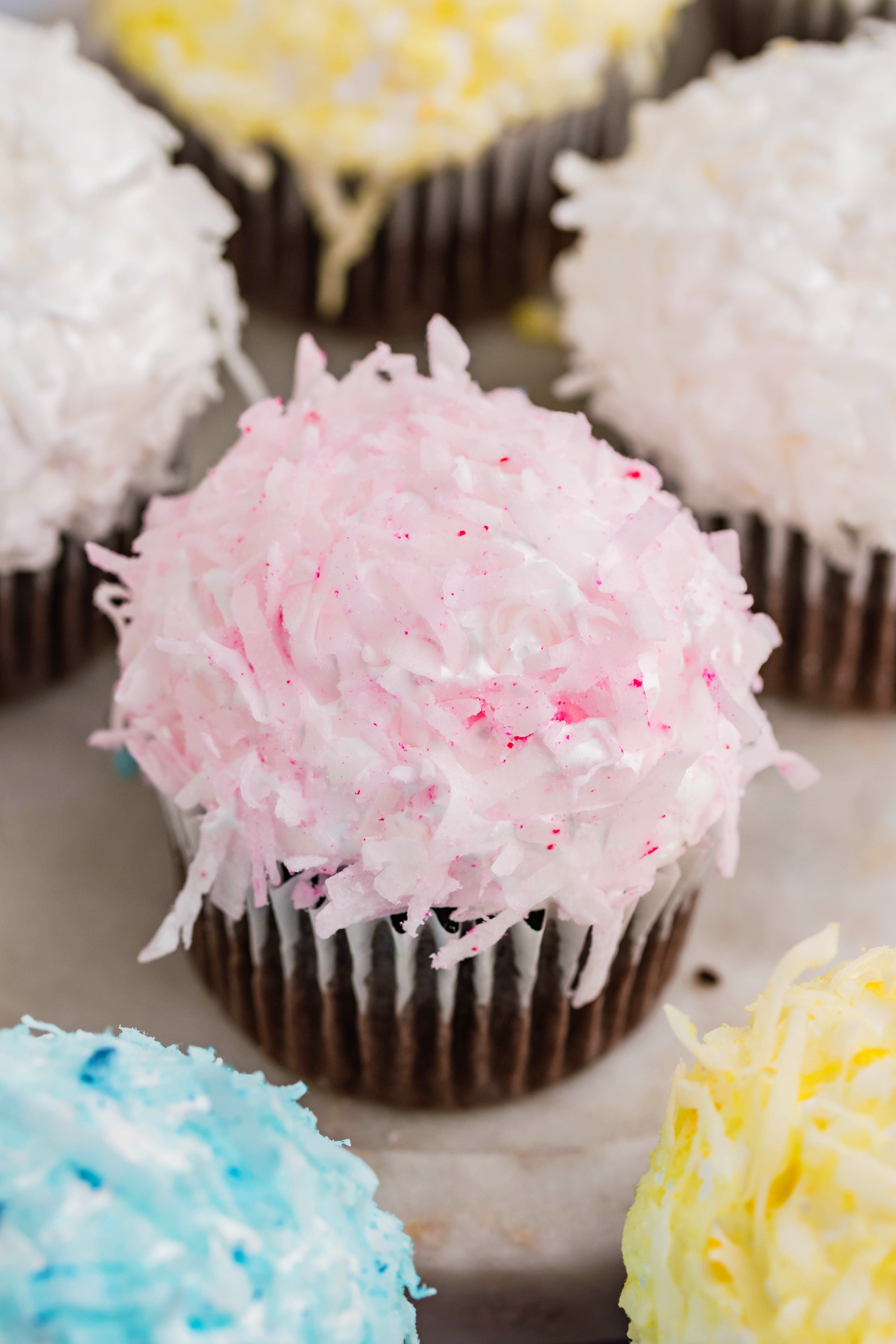 chocolate cupcake with pink coconut shavings & marshmallow frosting on a marble platter