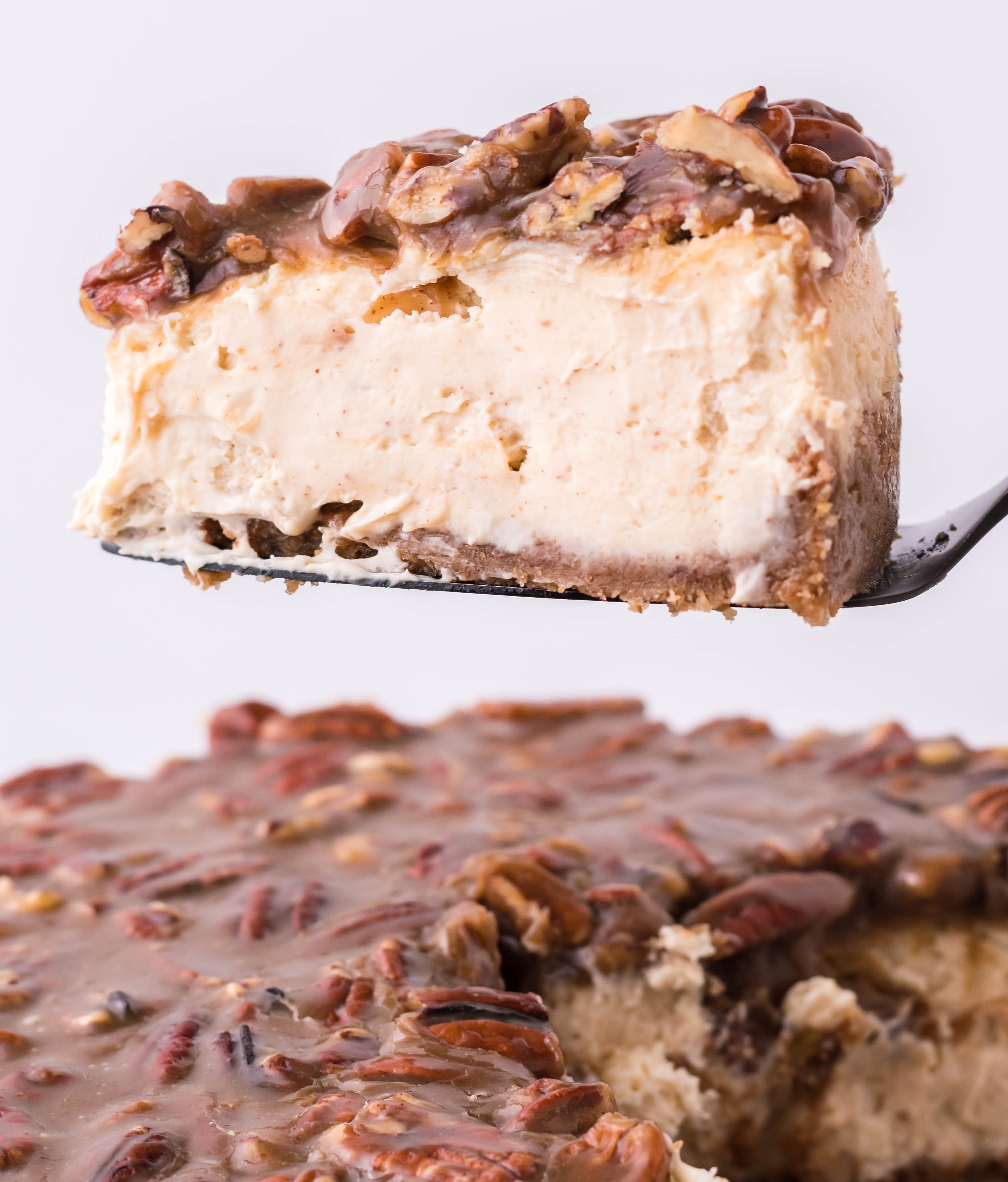 pecan pie Cheesecake slice being lifted up on a cake cutter