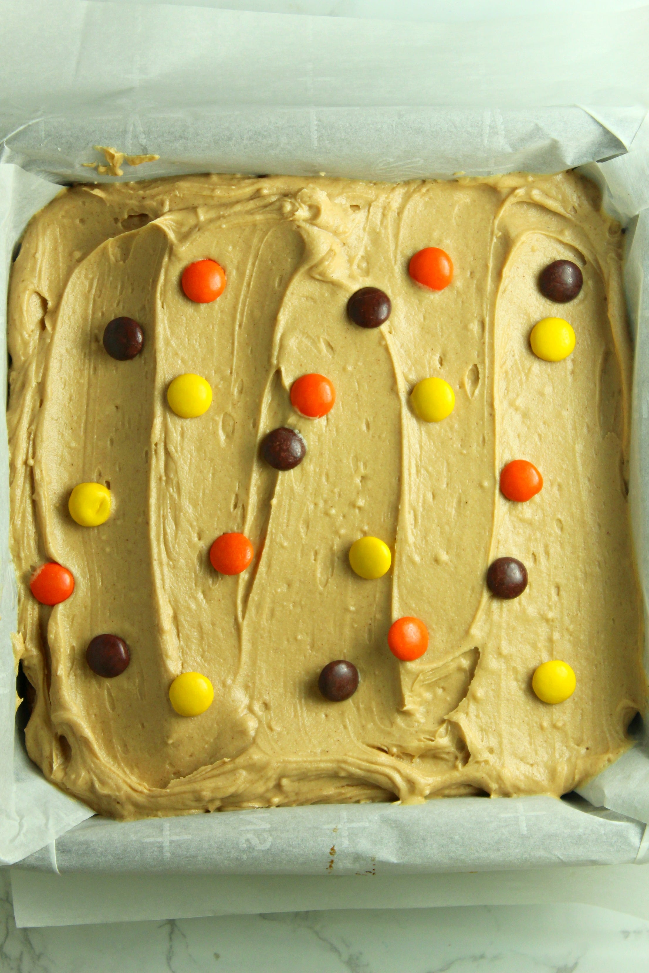 Peanut Butter Bars topped with peanut butter frosting & reeses pieces uncut