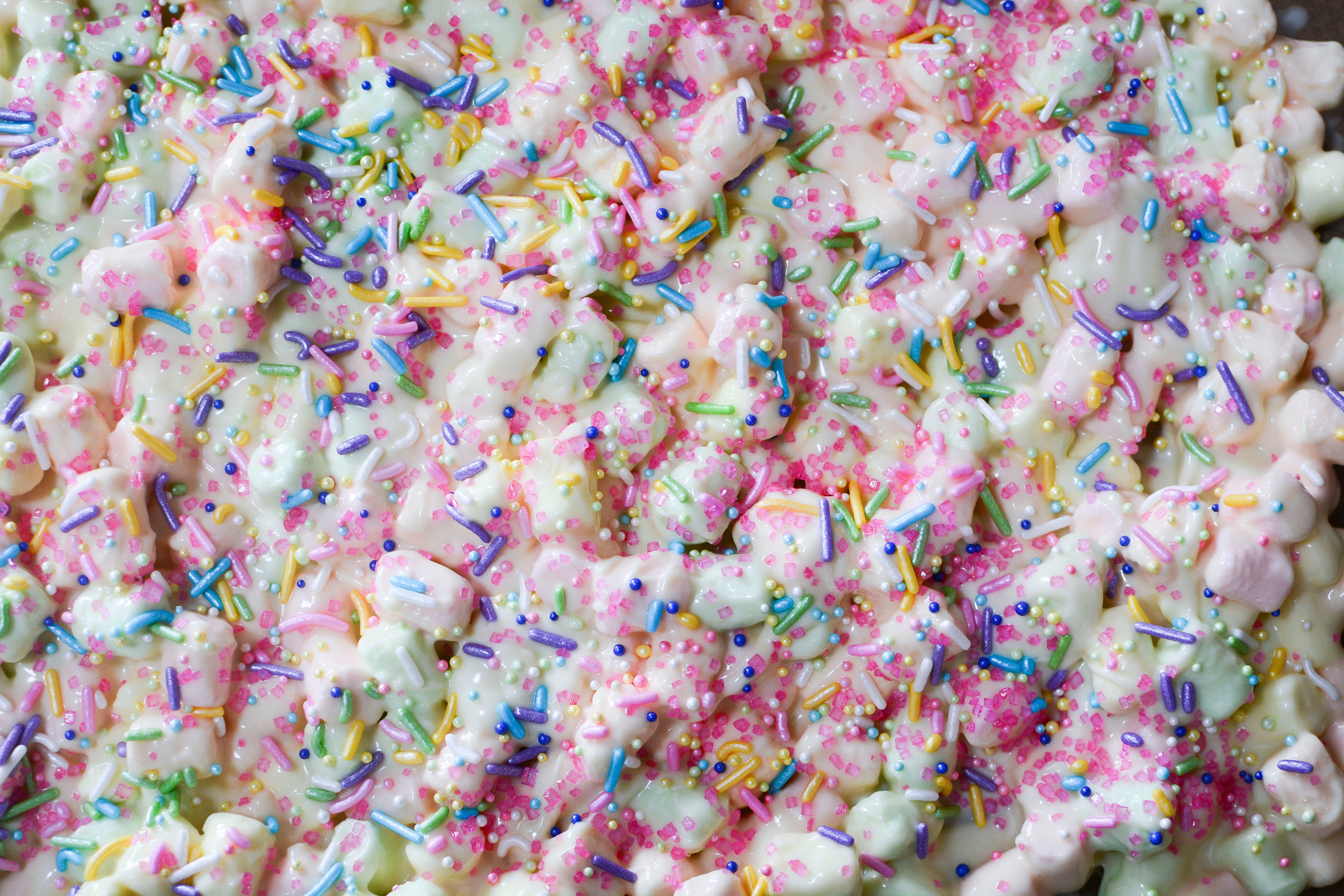Easter Marshmallow treats with pink, green and yellow mini marshmallow laying on a cookie sheet